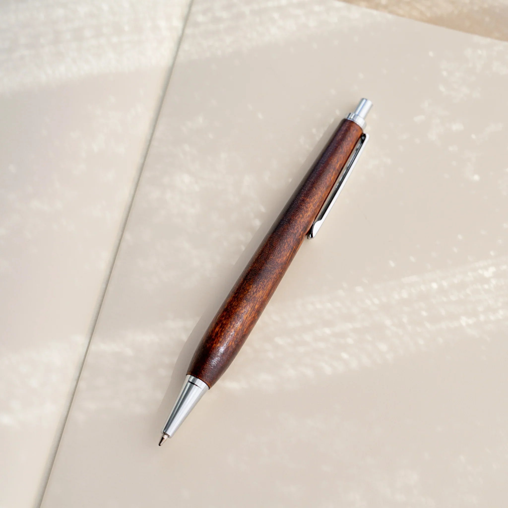Horse chestnut wood urushi lacquered ballpoint pen in amber-brown on white, Japanese wood, silver knock and clip