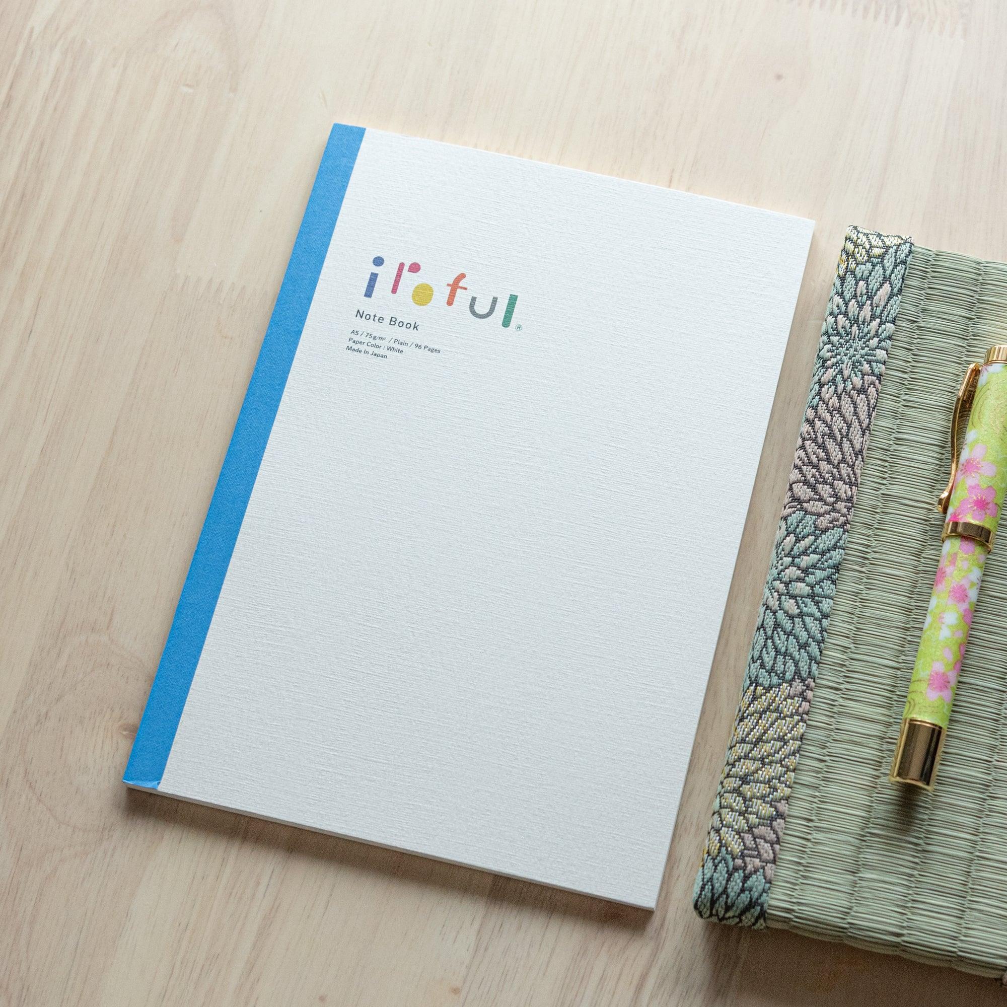 Iroful indigo-dyed A5 notebook, fanned pages showing binding flexibility and indigo dye color depth with natural indigo dye