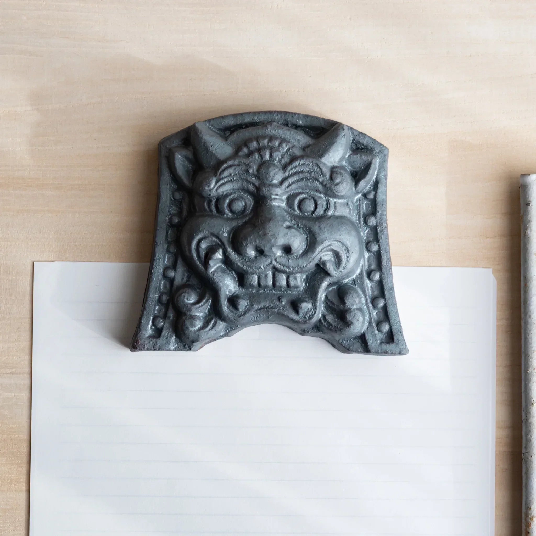 Japanese Kawara large roof guardian ceramic paperweight with resolute expression shown shown in composition