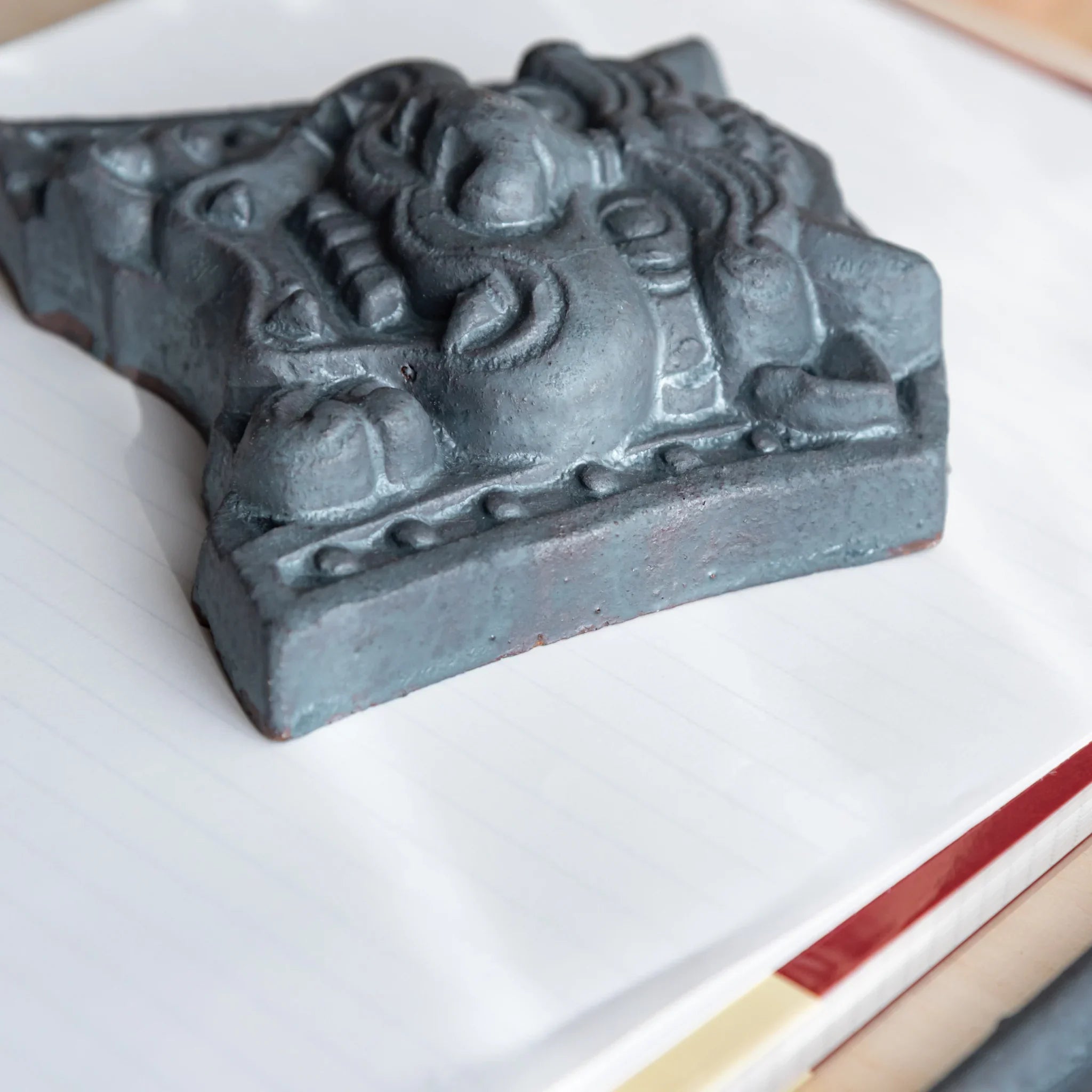 Japanese Kawara large roof guardian ceramic paperweight with resolute expression shown in composition detail
