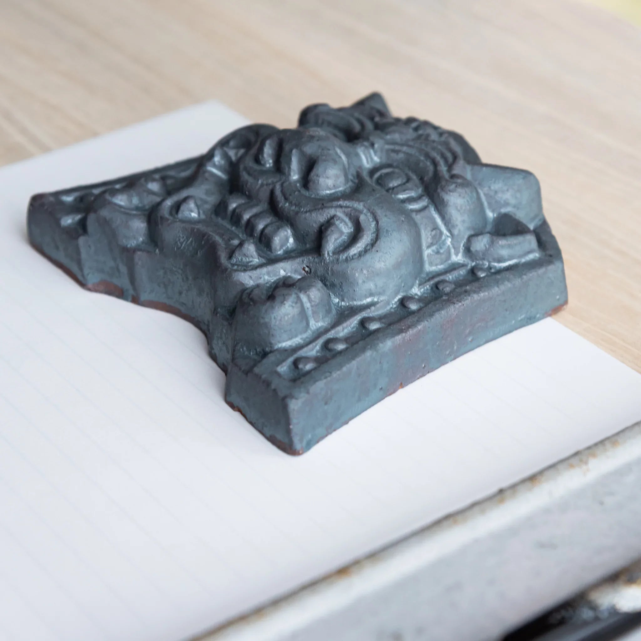 Japanese Kawara large roof guardian ceramic paperweight with resolute expression shown in composition view