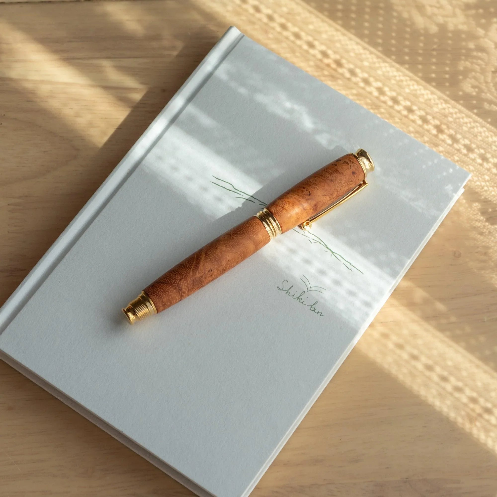 Japanese Karin Wood Screw Cap Fountain Pen side profile showing wooden body with decorative metal band trim