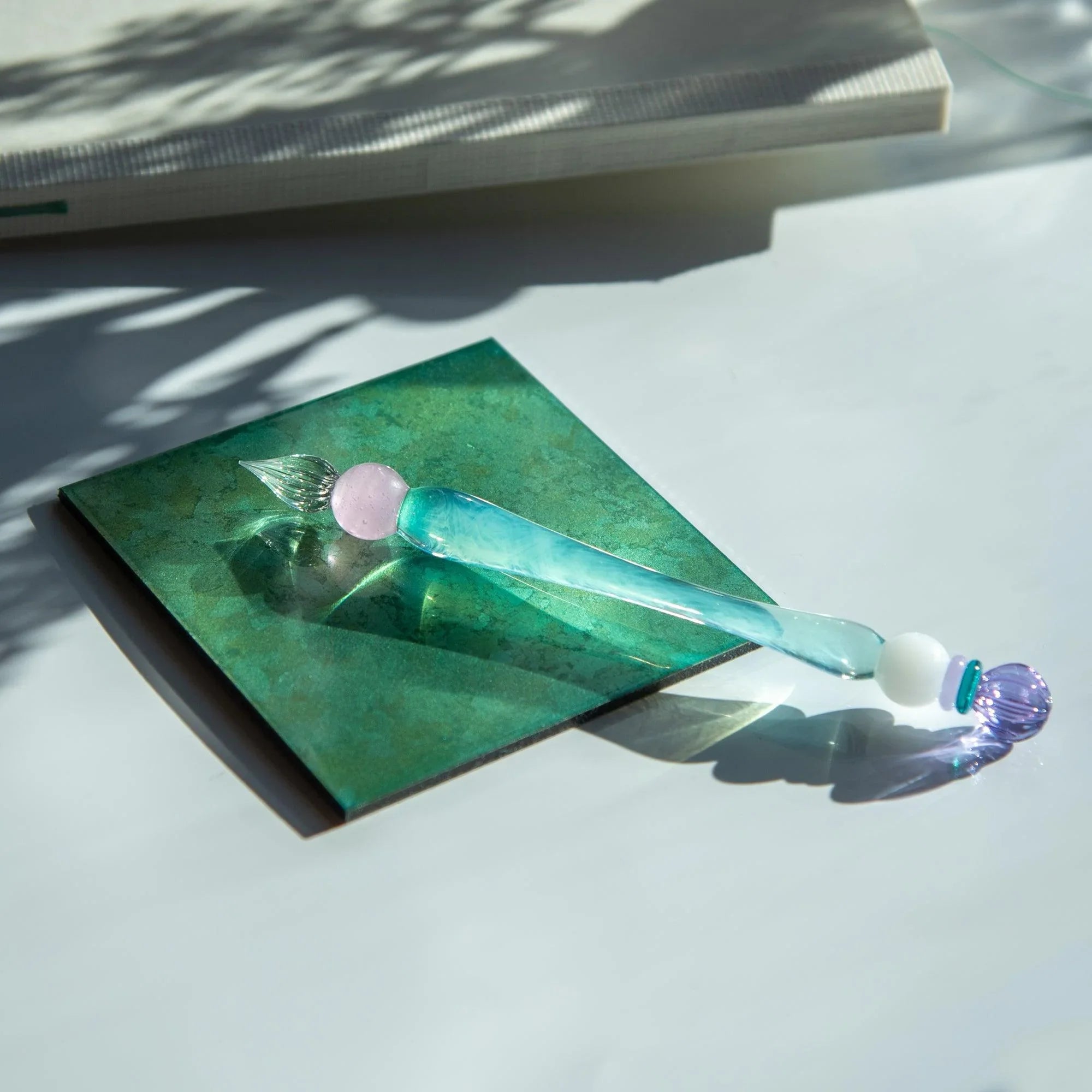 King's Scepter Candy pen on green marble surface with nib dipped in ink bottle lifestyle shot with handle detail and