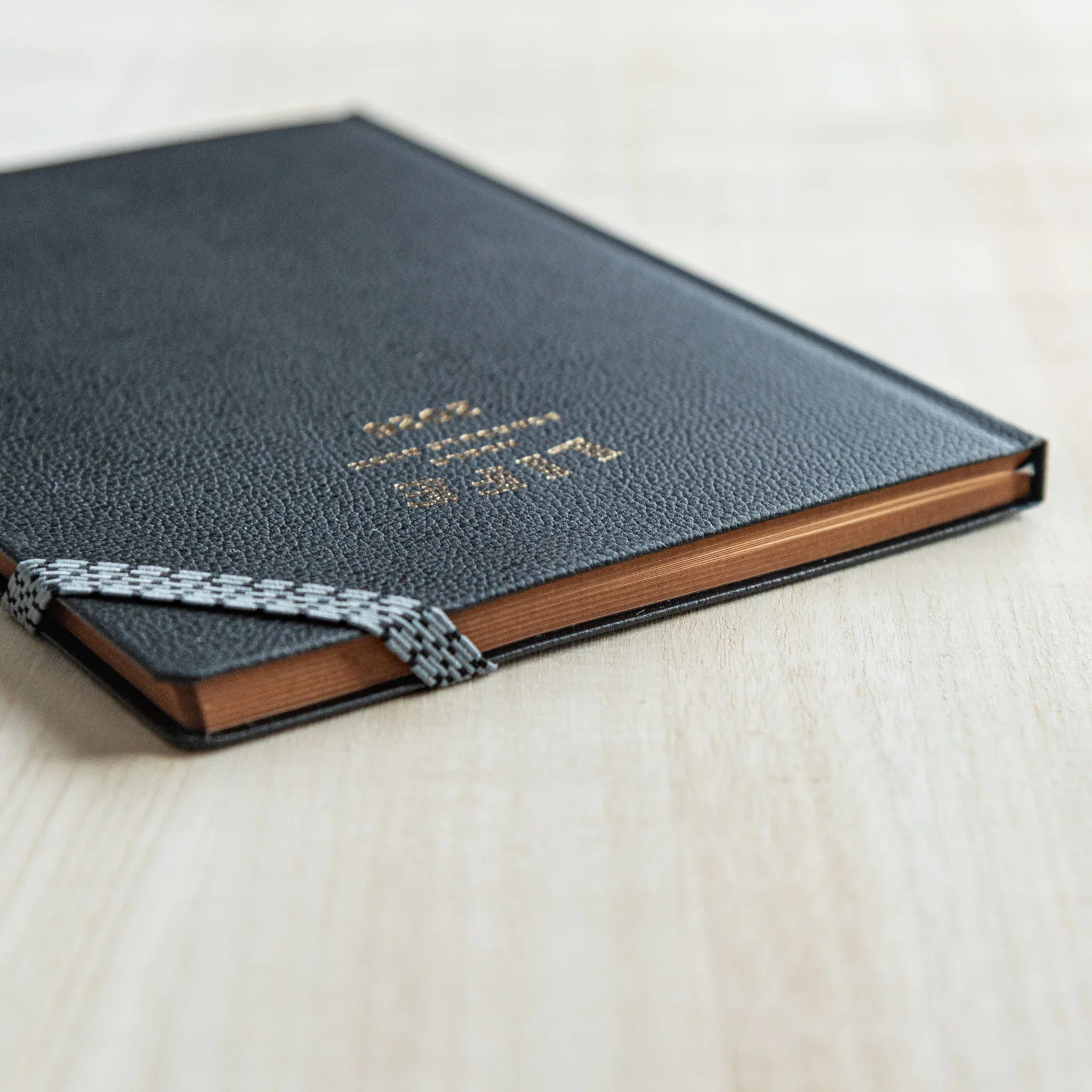 Life Noble 2026 schedule book featuring navy leather, open showing pages showing gold lettering               