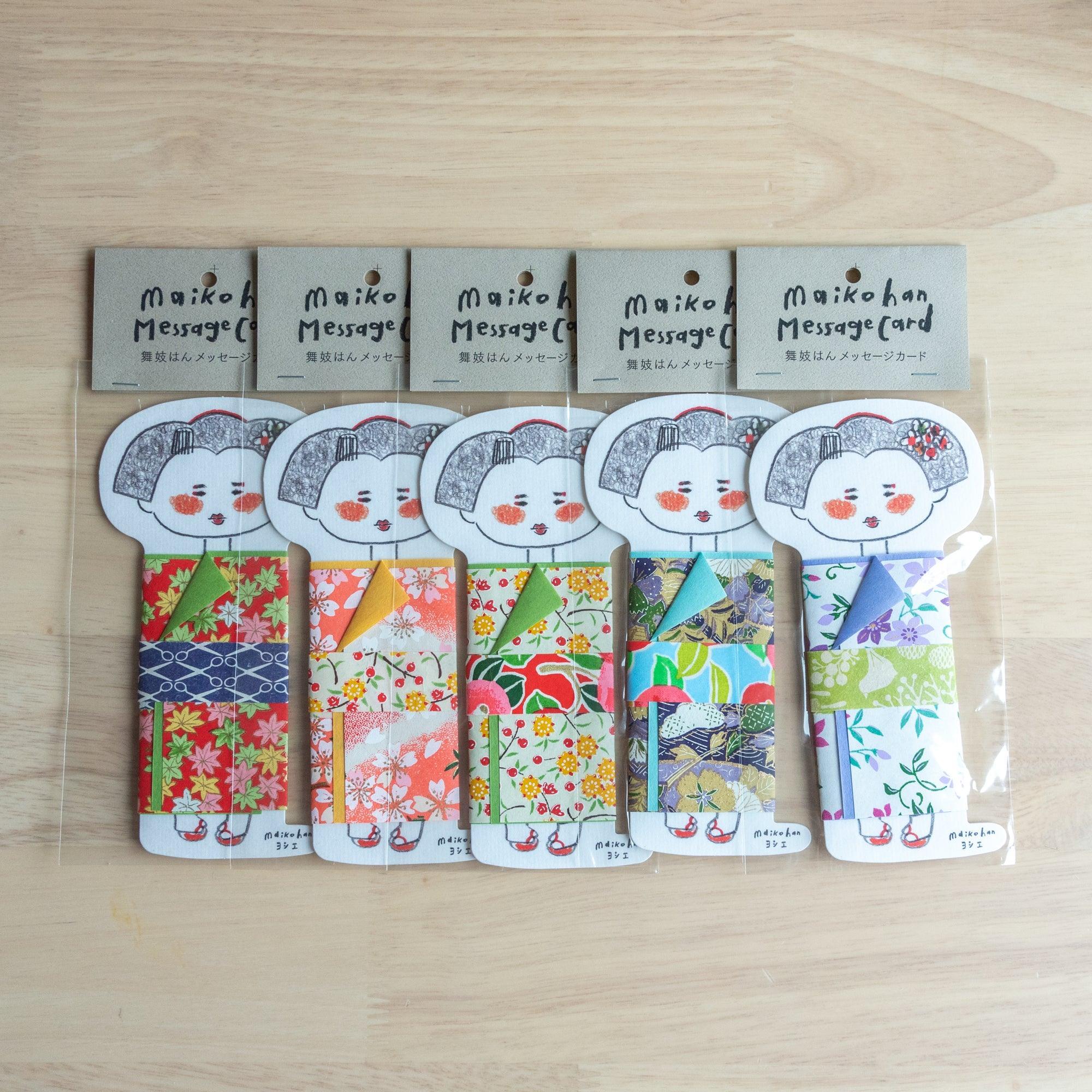 Five Maikohan Message Card packages on wood, each with a gray-haired maiko figure in a different yuzen washi kimono pattern
