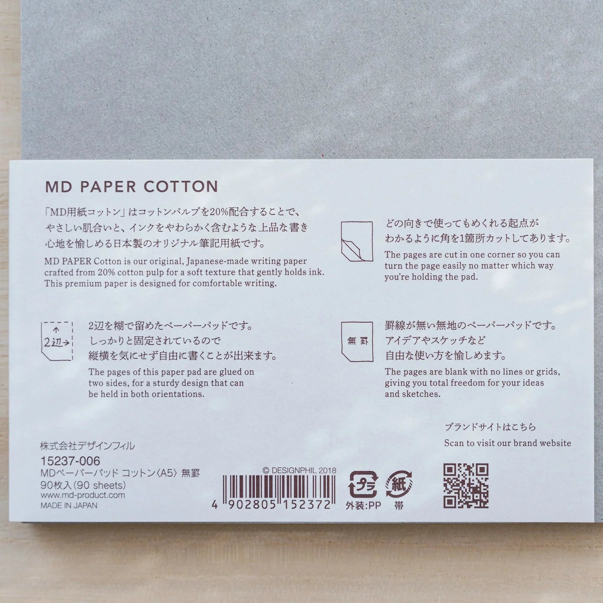 Close-up of Midori MD Paper Pad Cotton A5 belly band text on 20% cotton paper, 90 sheets, blank, cut corner