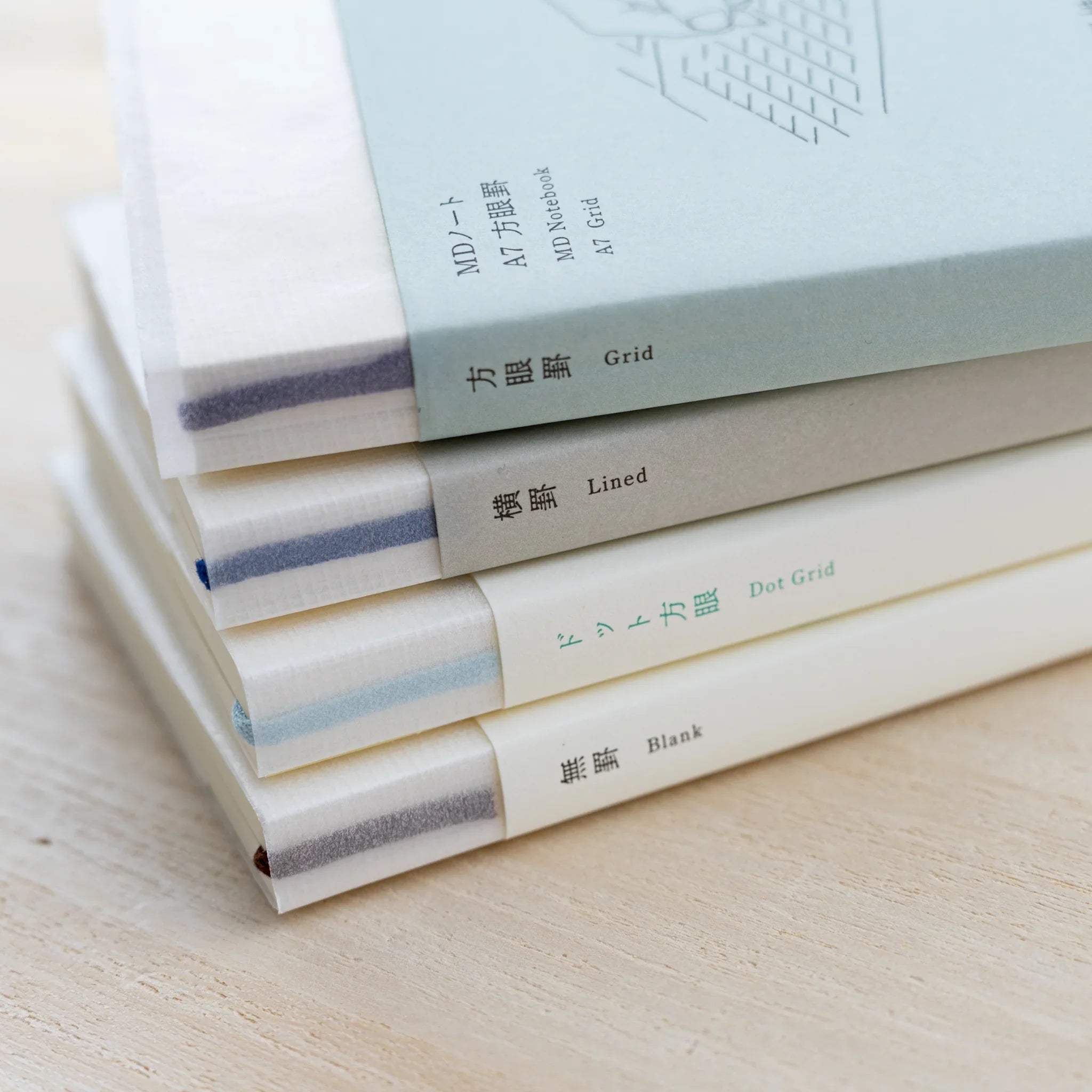 Stack of four MD Notebook A7 books with spine labels for Blank, Lined, Grid and Dot Grid