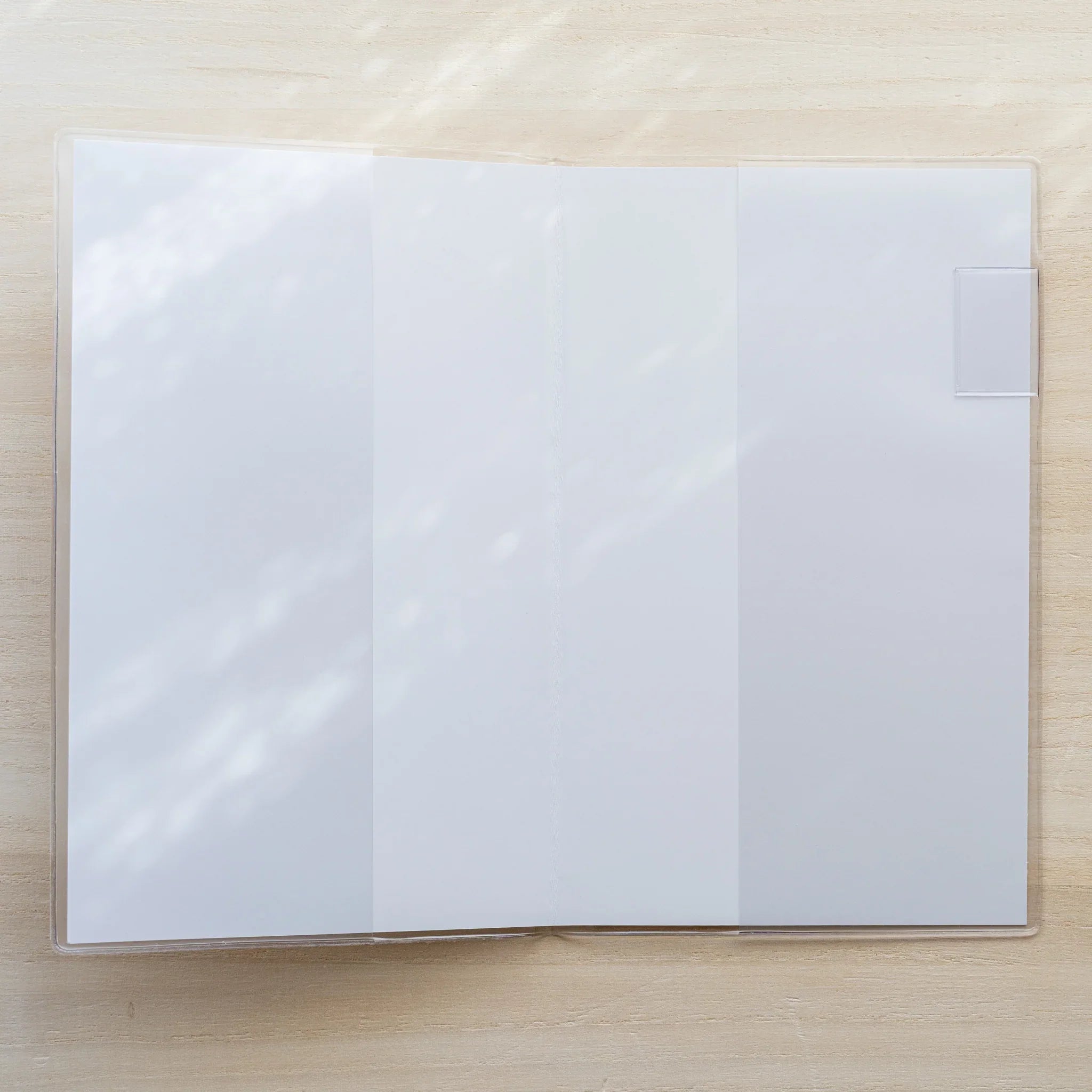 MD Notebook Cover opened flat in clear PVC showing a blank white spread with a white bookmark tab