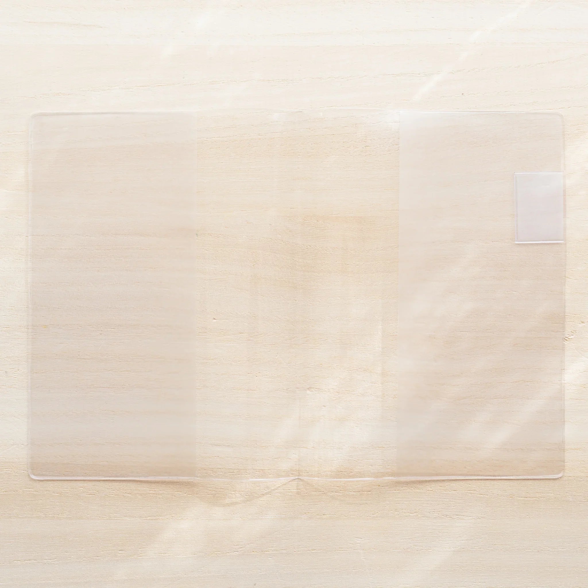MD Notebook Cover opened flat in clear PVC showing a blank white spread with center fold