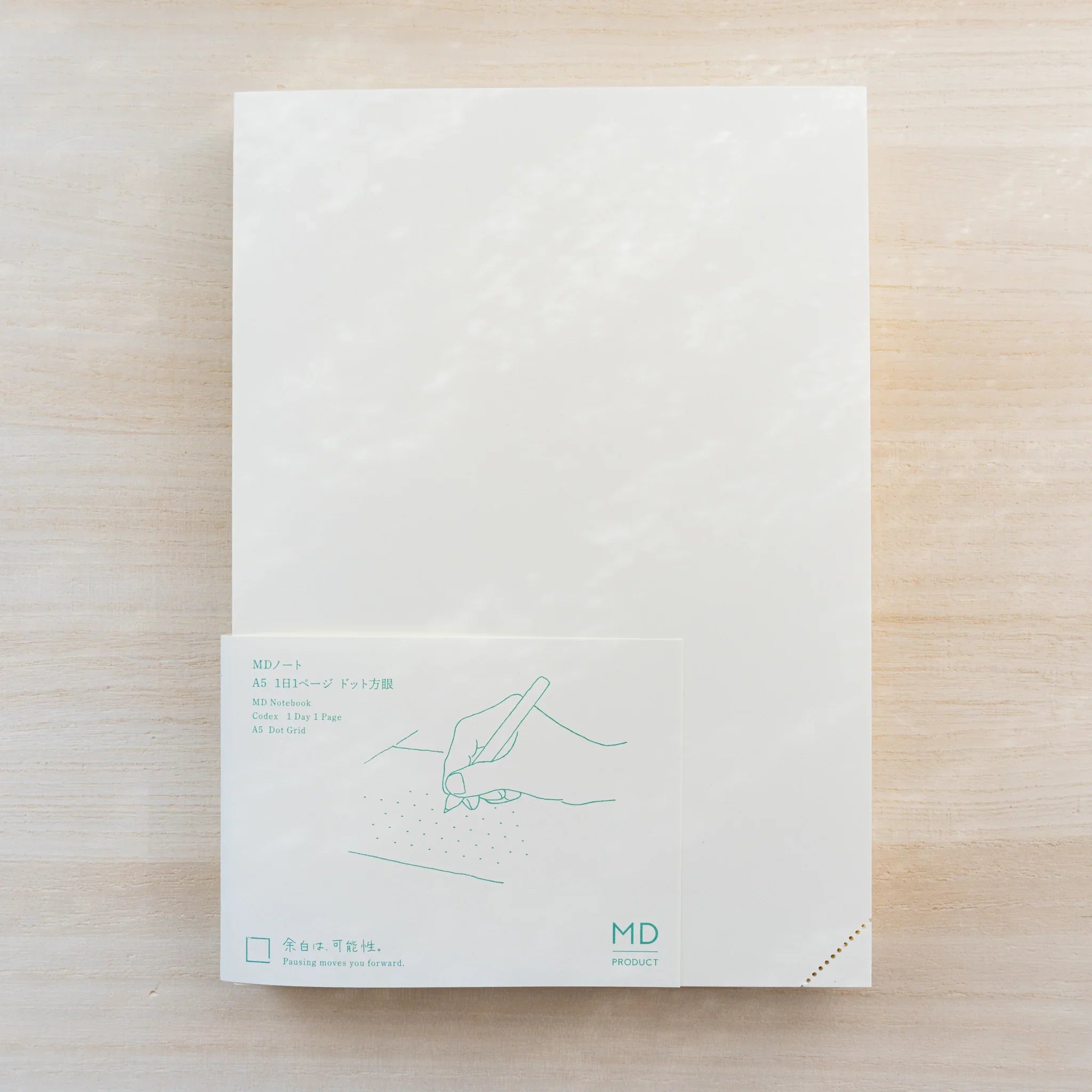 Midori MD Notebook Journal Dot Grid cream cover with green paper belly band reading A5 Dot Grid and hand-writing drawing