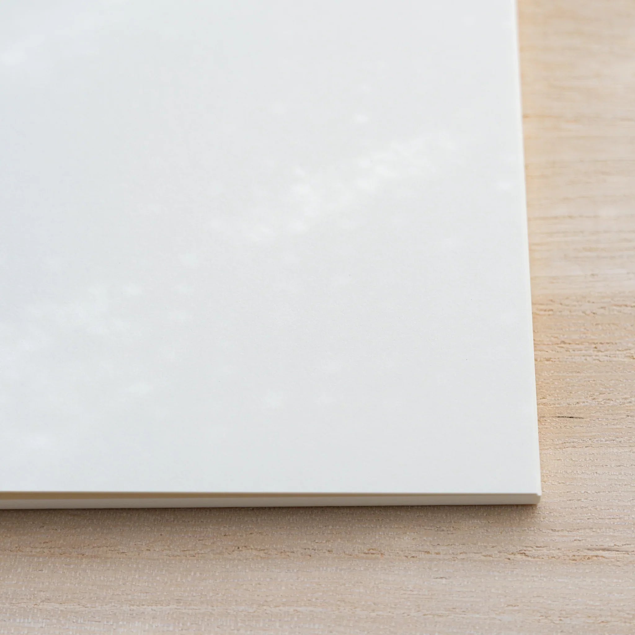 Close-up corner of closed Midori MD Notebook Thick showing the white cover and cream page-block edge