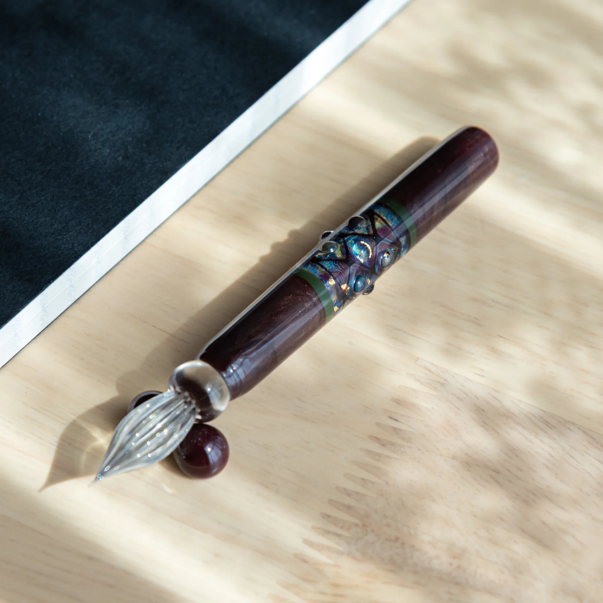 Mirror sphere glass dip pen close-up showing dark wooden handle and shiny reflective glass ball ornament