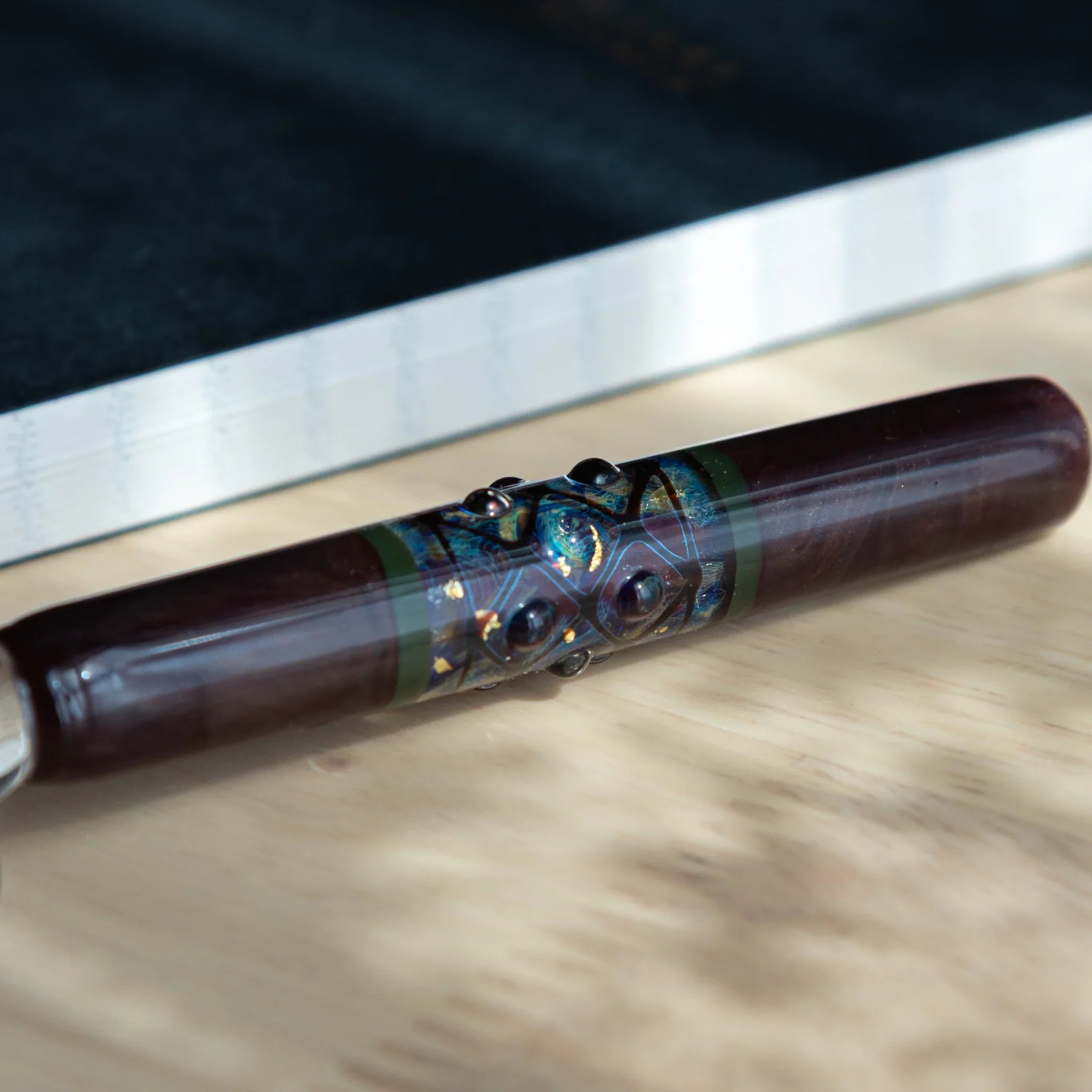 Japanese mirror sphere glass dip pen with reflective glass ornament accent displayed beside dark notebook