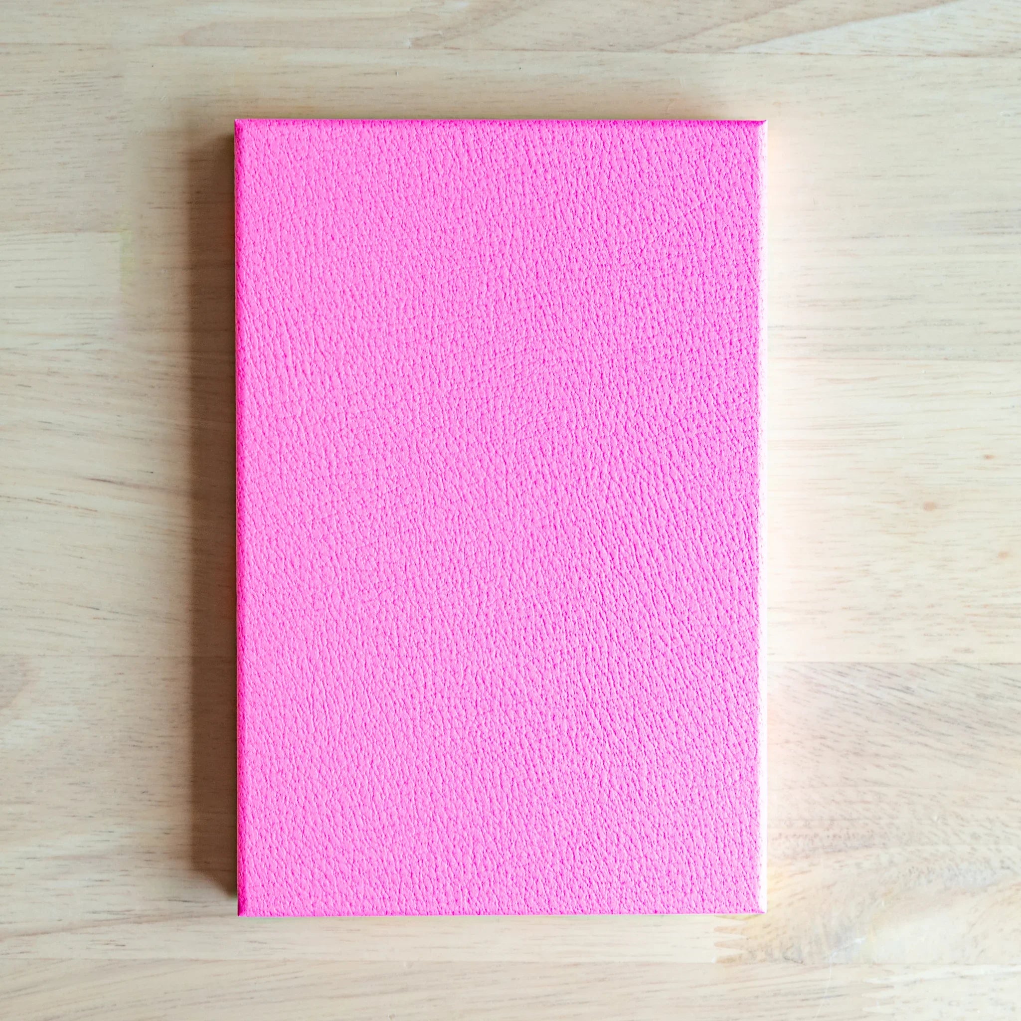 Neon Camellia washi goshuincho back cover showing solid neon pink textured surface on light wood