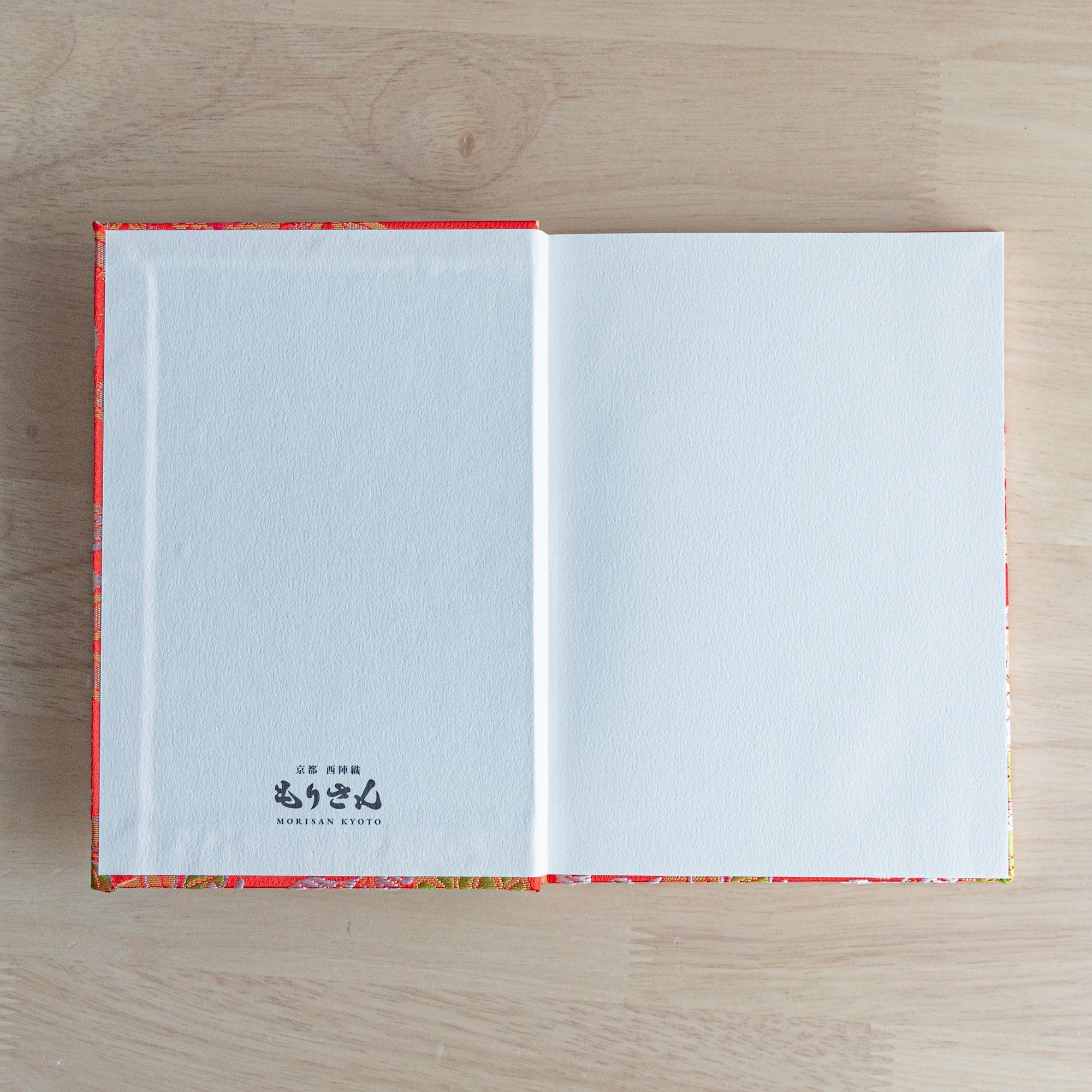 Opened Nishijin textile Japanese notebook with white endpaper and Morisan Kyoto branding on left and blank white right page