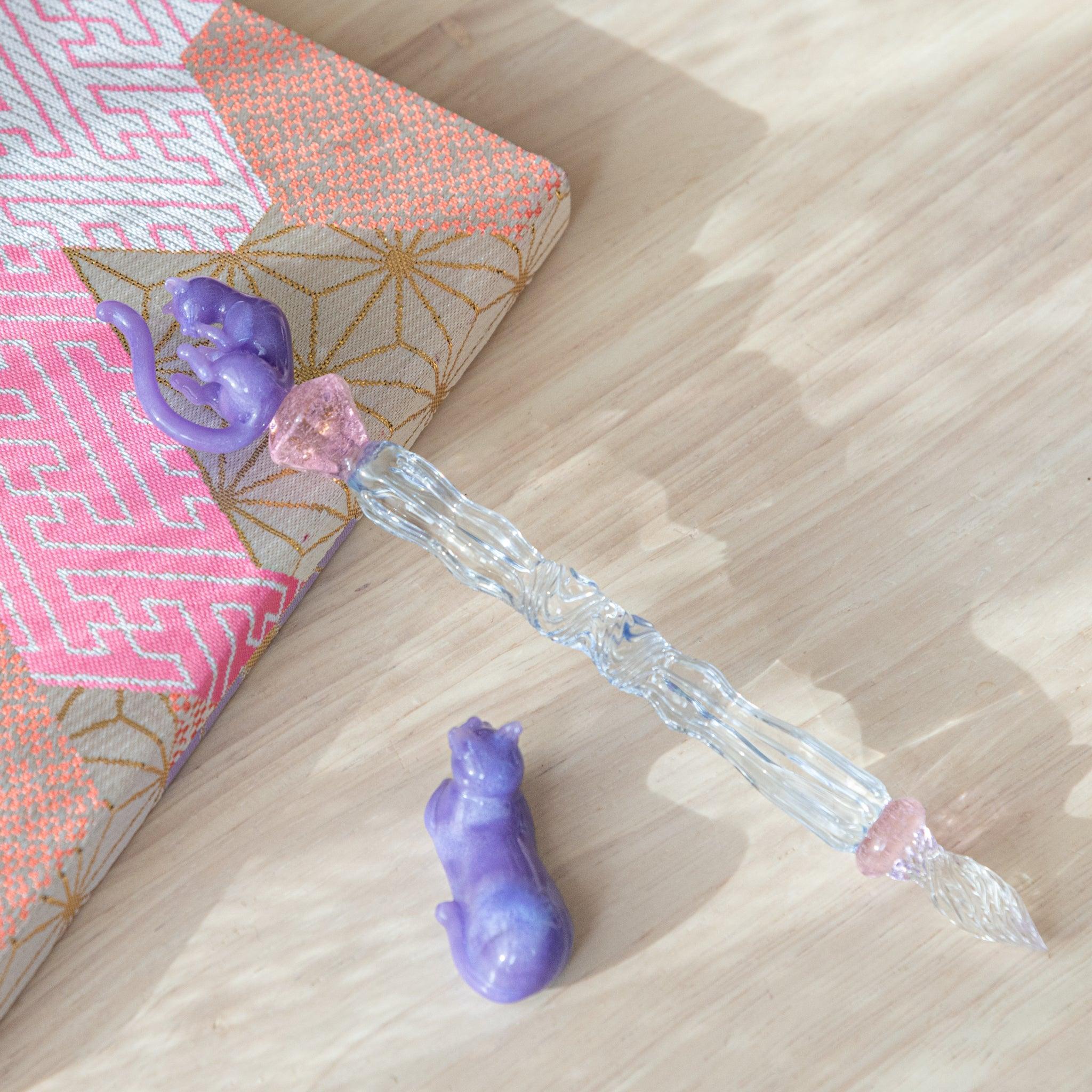 Pastel Purple Cat Glass Dip Pen with adorable cat face profile on barrel next to its matching ceramic pen rest