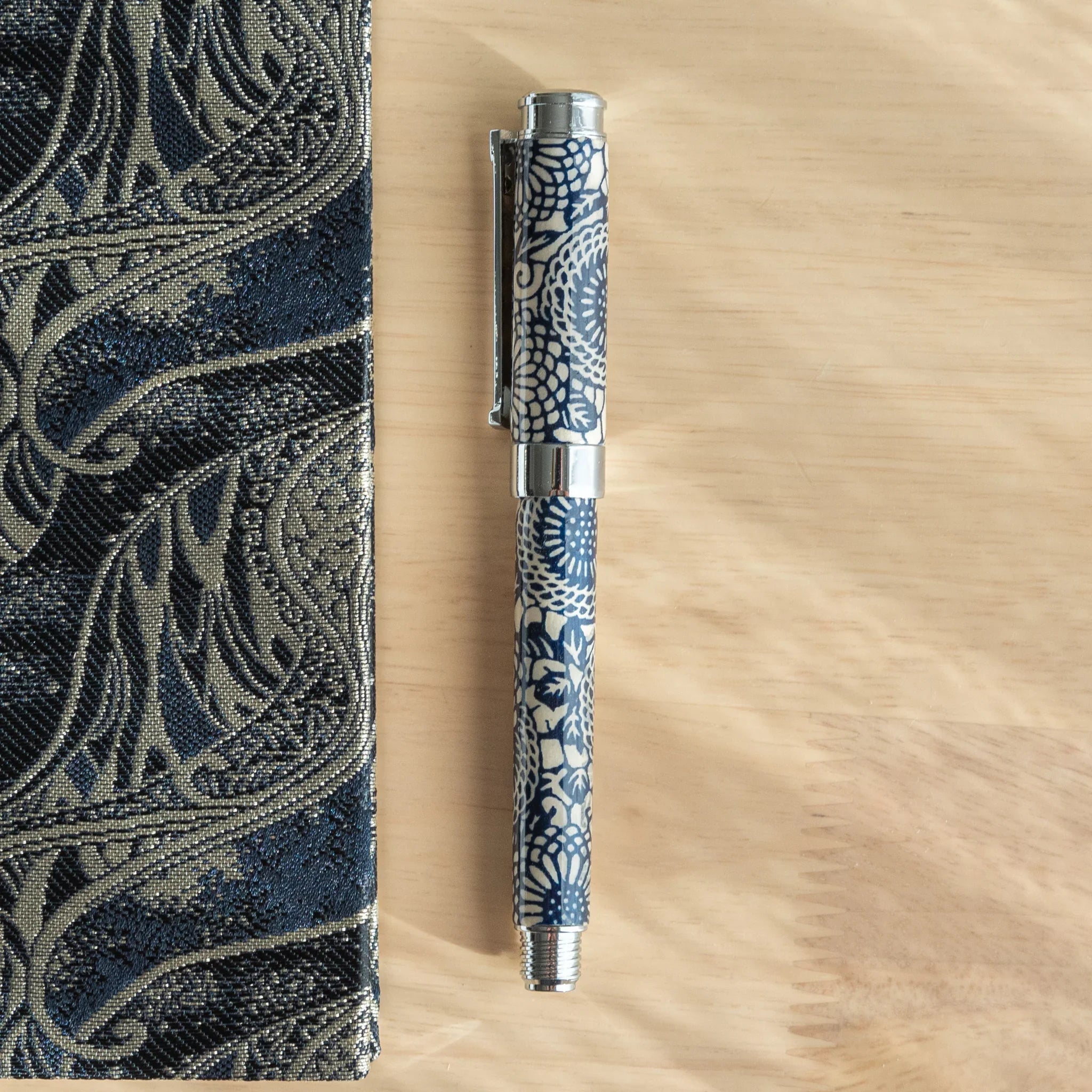 Peony Mino washi fountain pen with navy background featuring white peony flower pattern and wrapping angled view