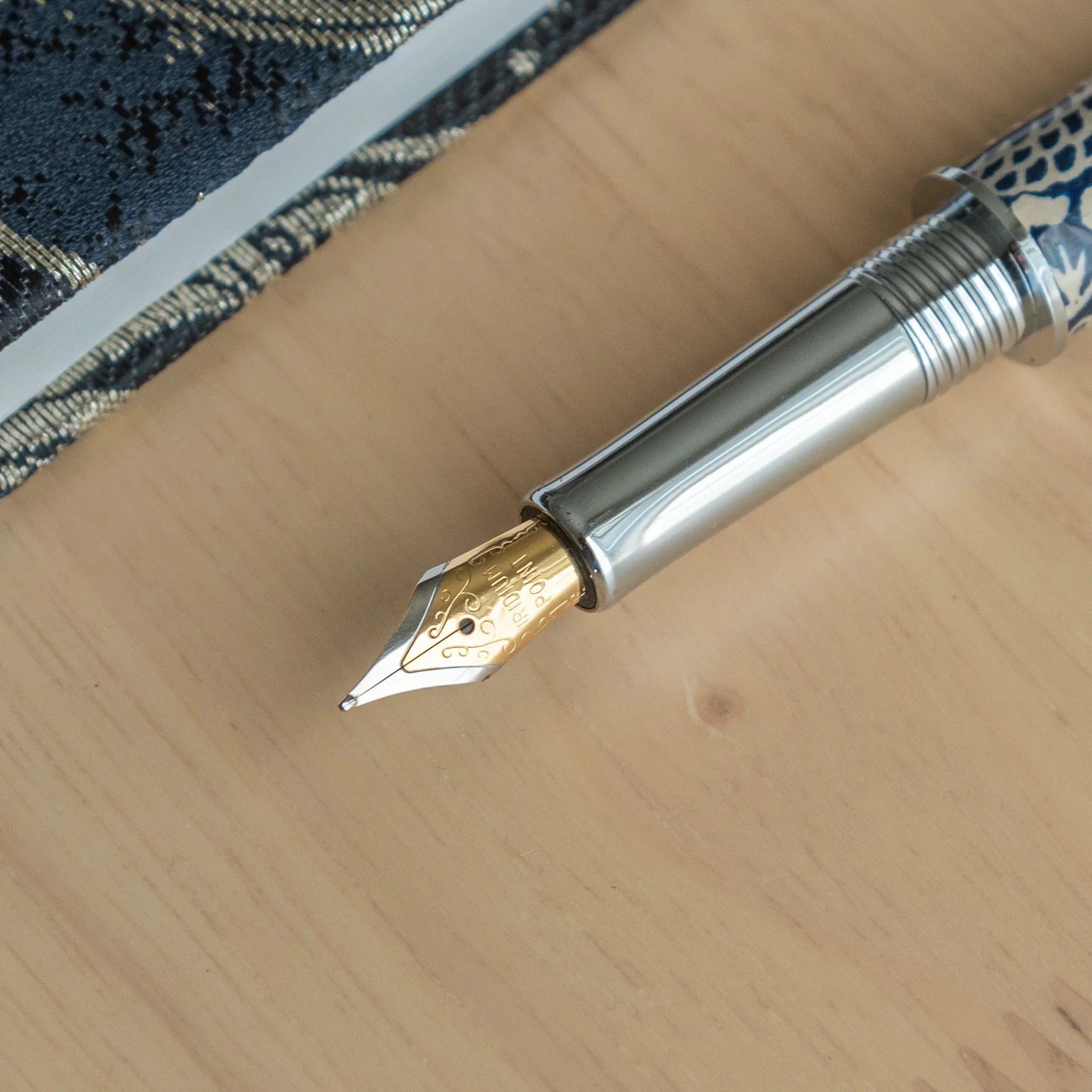 Peony Mino Washi fountain pen positioned on background with navy blue wrapper decorated in white peony flower motif pattern