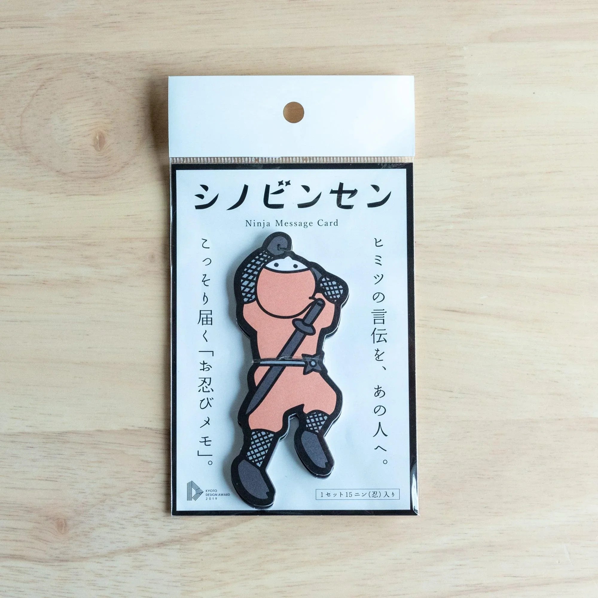 Packaged Shinobi-nsen Ninja Message Card set with a pink die-cut ninja card on a black backing, 15 cards per set, on wood