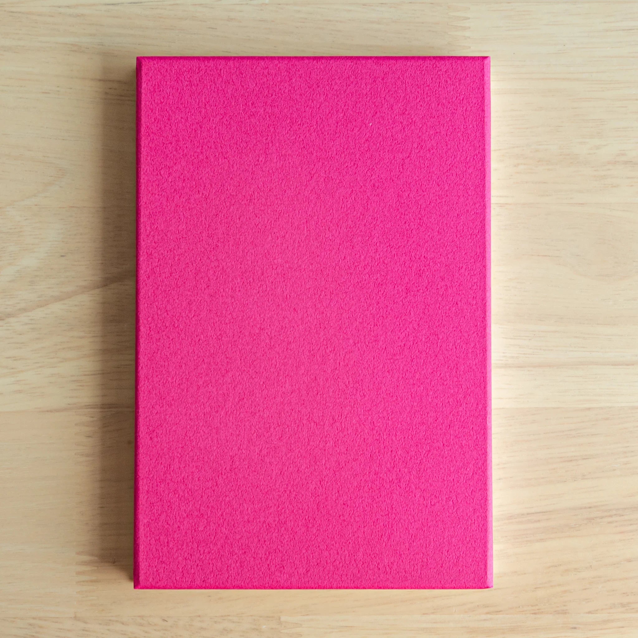 Pink Plum Blossoms washi goshuincho back cover showing solid hot pink textured surface on light wood