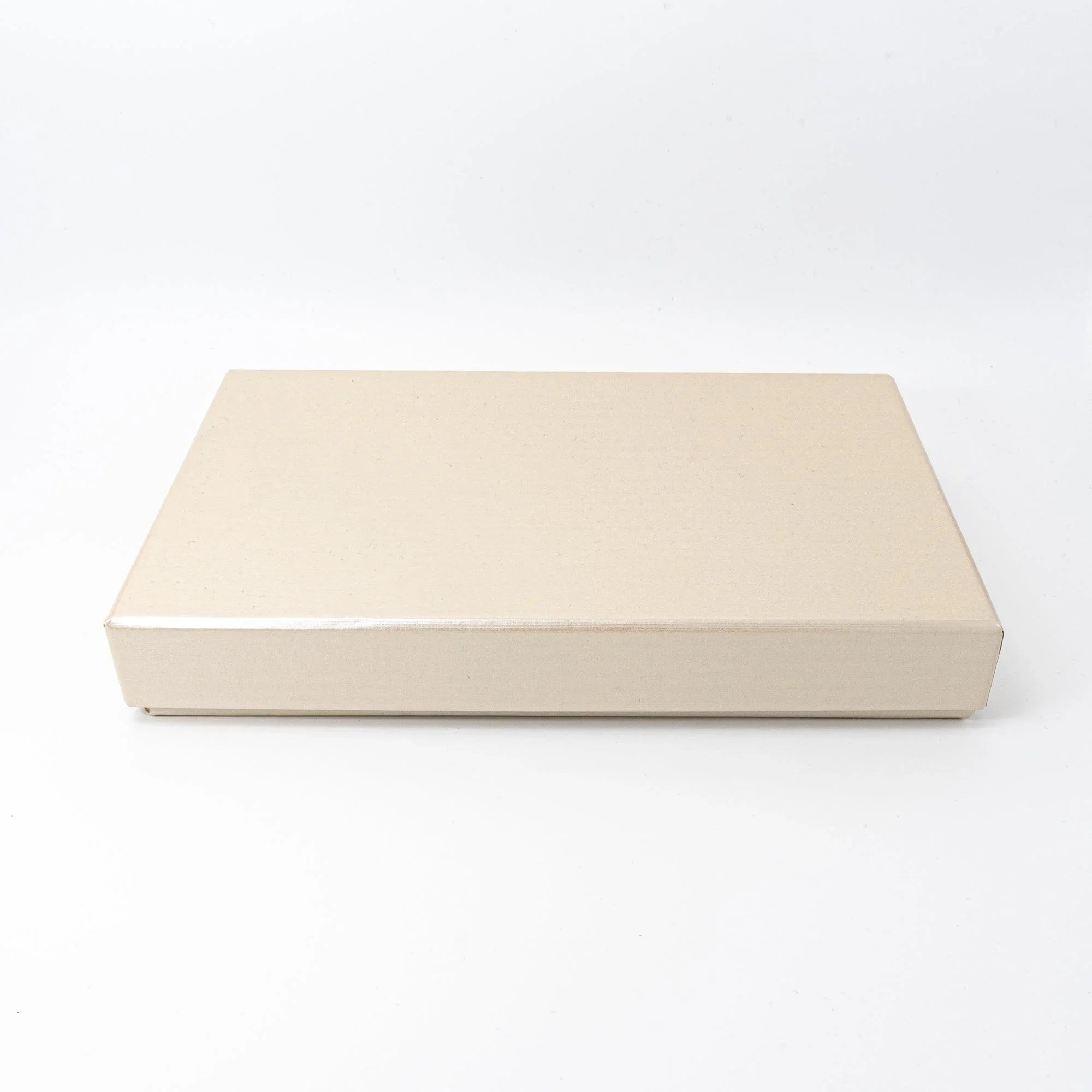 Closed cream gift box for plum shippo ware pen tray, shown closed from a side angle on white background