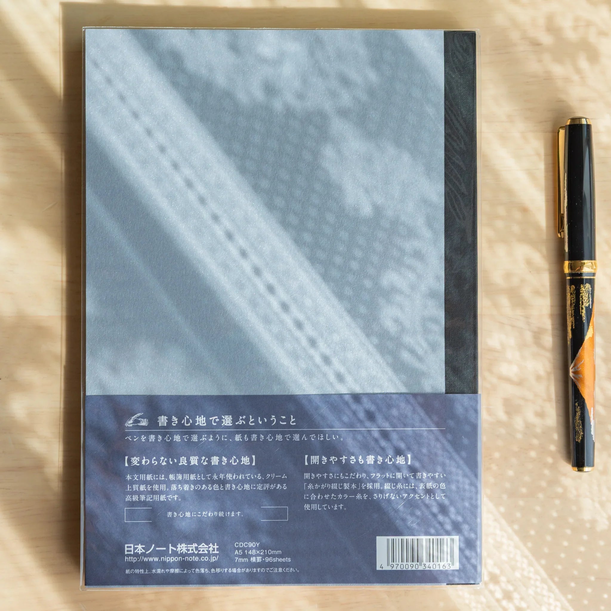 Apica Premium CD A5 notebook cream soft cover detail with open interior blue pages and fine quality line ruling visible