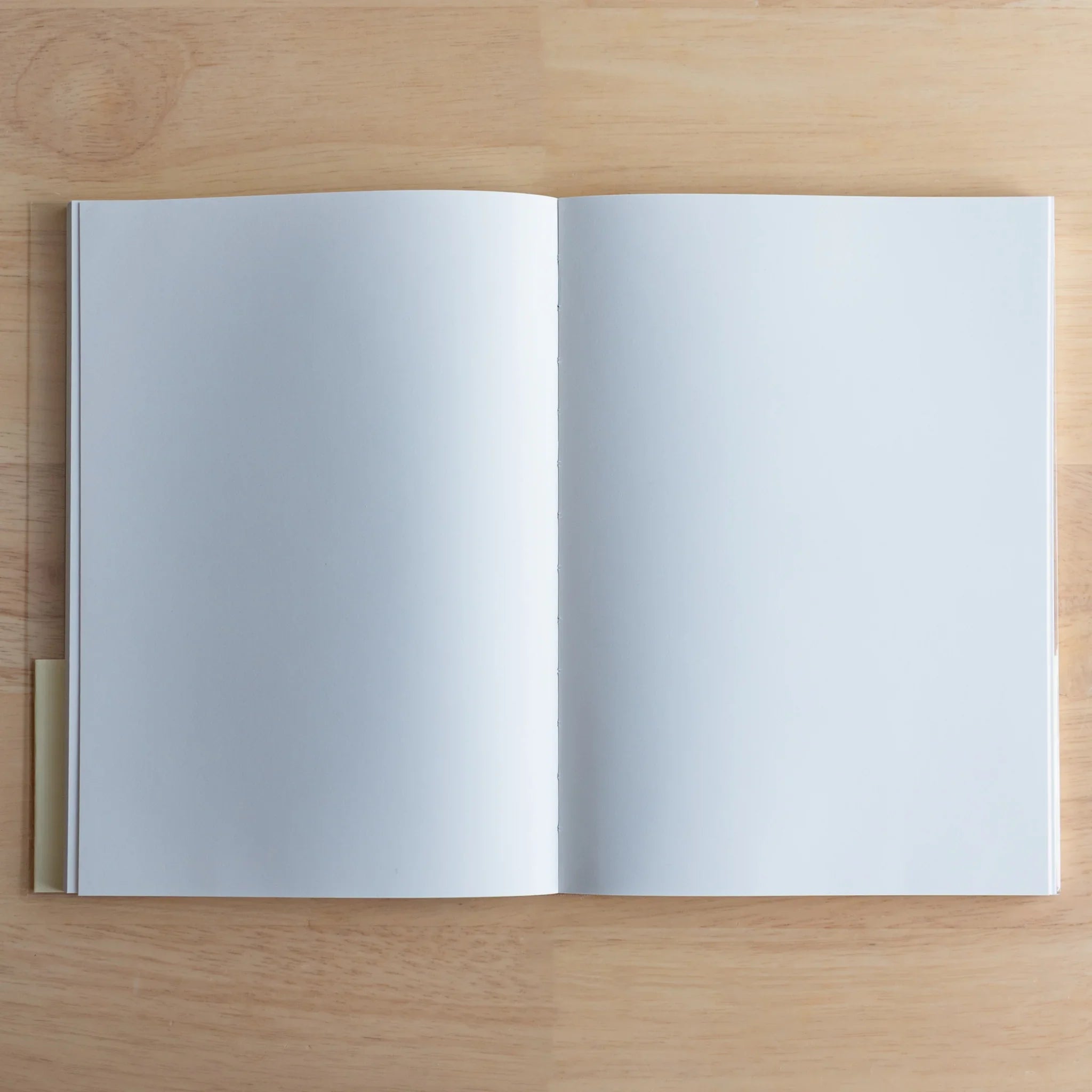 Apica Premium CD Fountain Pen Notebook Silky open showing blank white interior pages on wooden surface