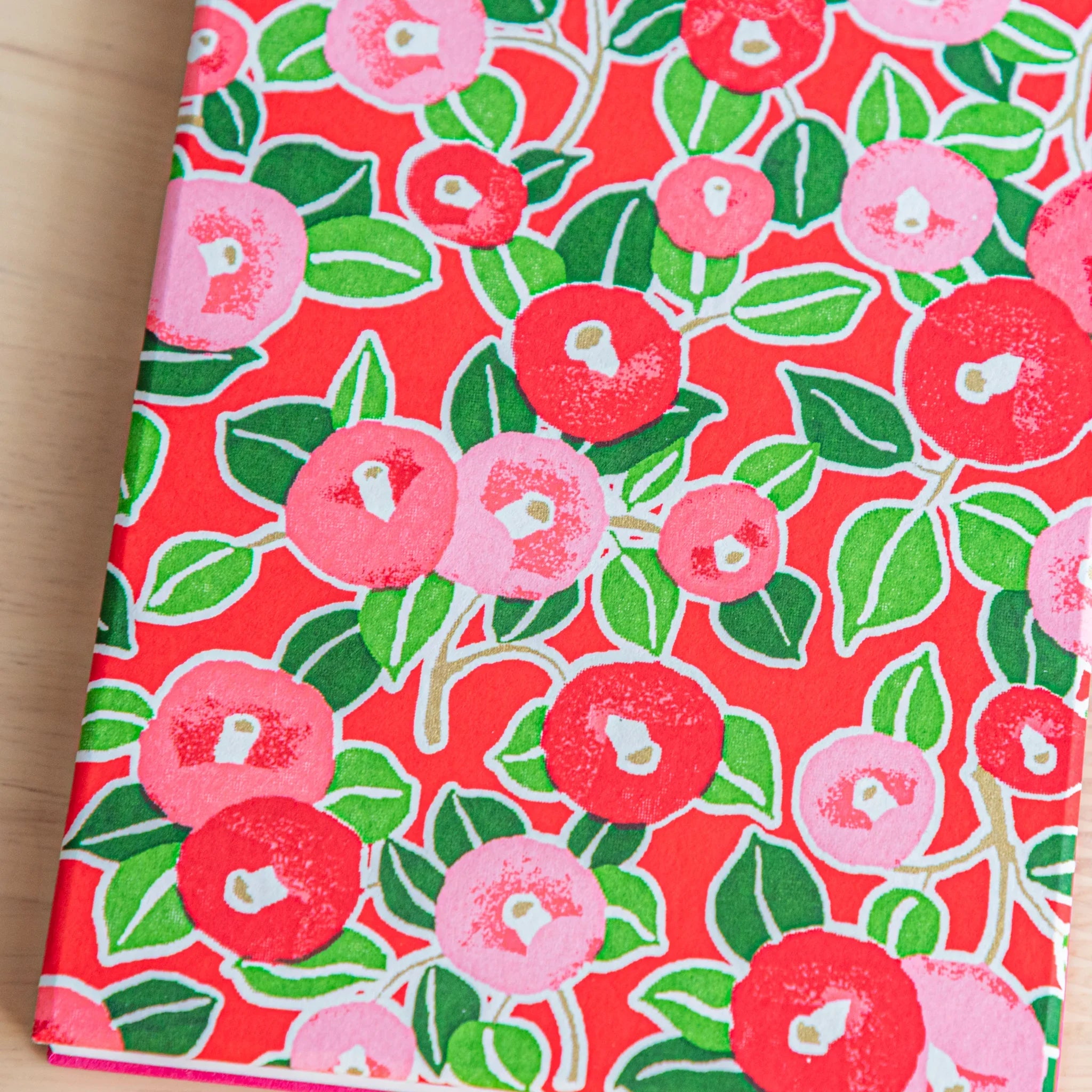 Red Camellia washi goshuincho close-up showing red and pink camellia flower pattern with green leaves on red background