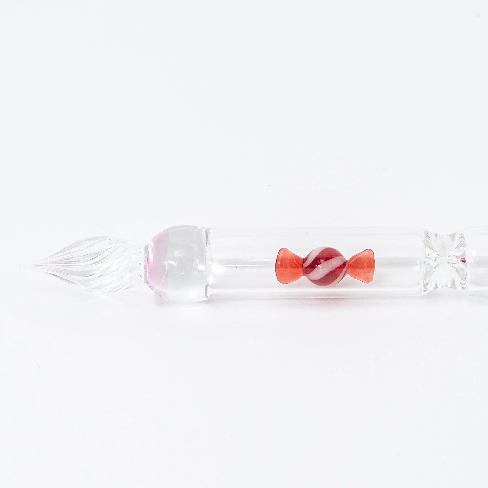 Red glass pen nib detail showing fine calligraphy point and artisanal candy bubble glass design element with holder