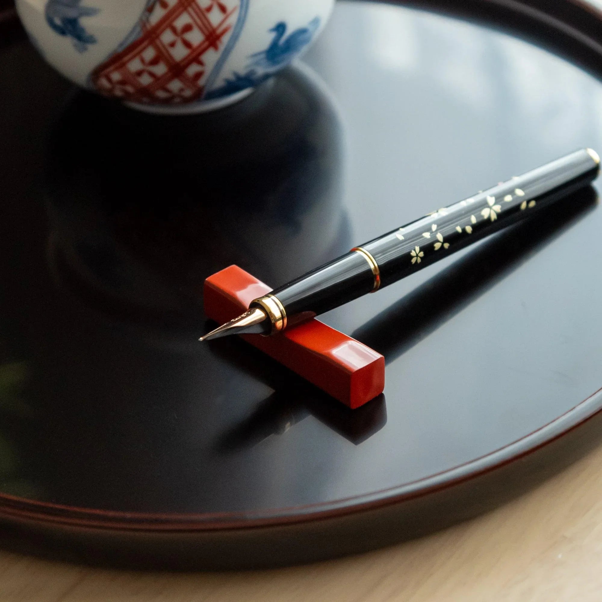Red Echizen lacquered sakura wood pen rest features traditional hand-finished lacquer coating, keeping pens secure during 