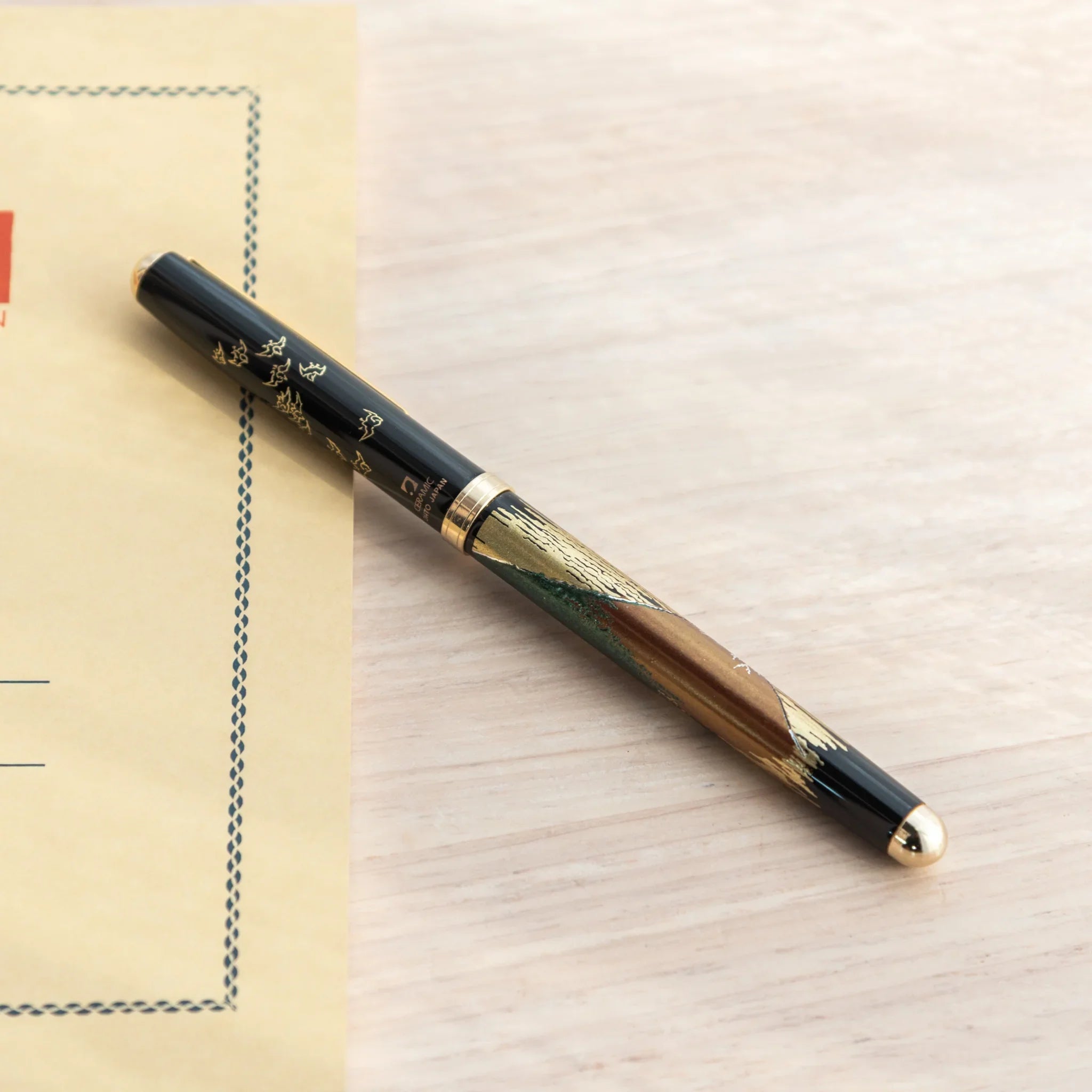 Hand-turned Yamanaka wooden ballpoint pen features red fuji mountain and gold accent lacquer art for writing