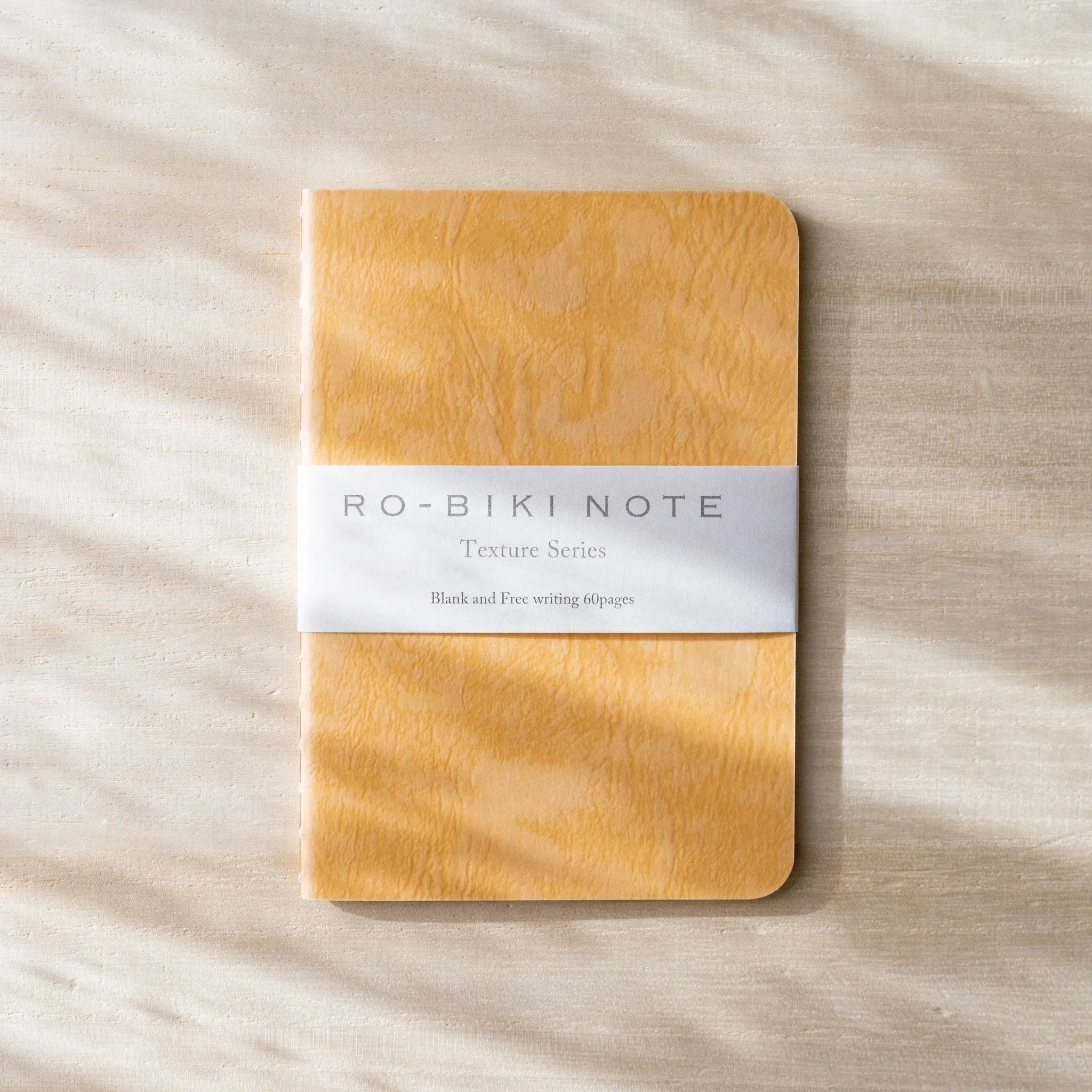 RO-BIKI NOTE tonoko beige waxed cover with black spine, blank notebook with paper belly band and logo