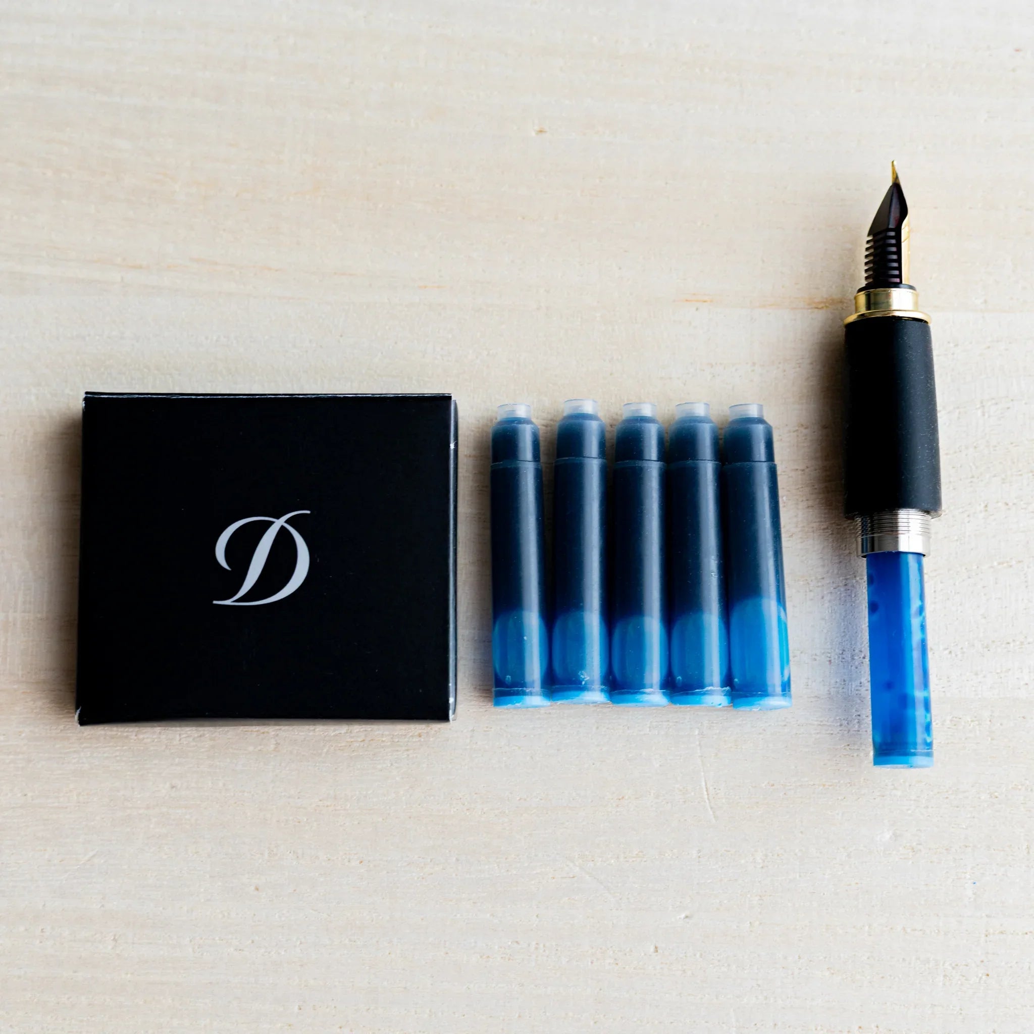 Black S.T. Dupont box with five blue ink cartridges and a pen section with gold nib and blue cartridge installed