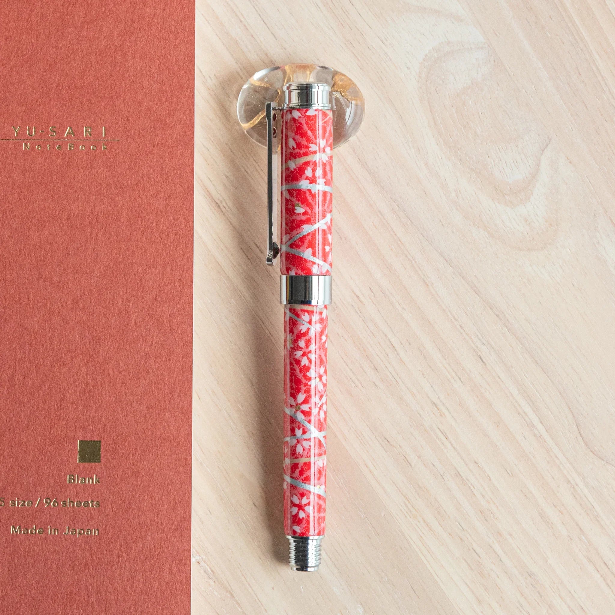 Sakura Hemp fountain pen uncapped vertical display featuring red Mino washi wrapper with white sakura and hemp leaf patterns