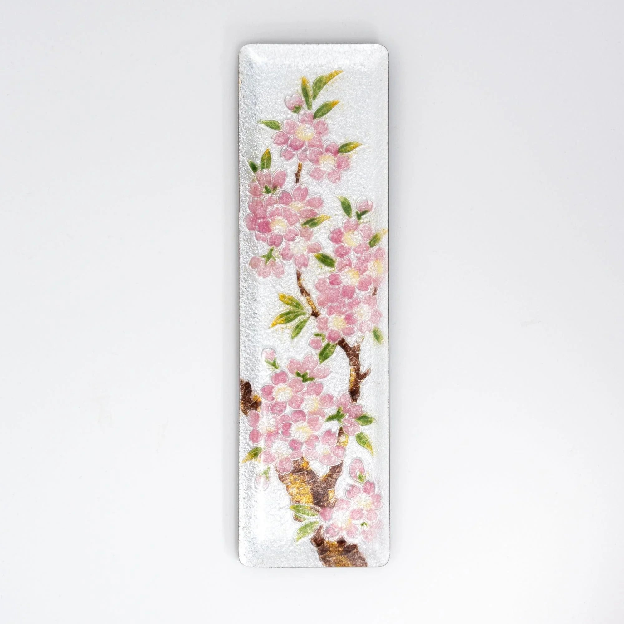 Silver enamel slim pen tray with pink sakura blossom and green leaf design, front overhead view on white background