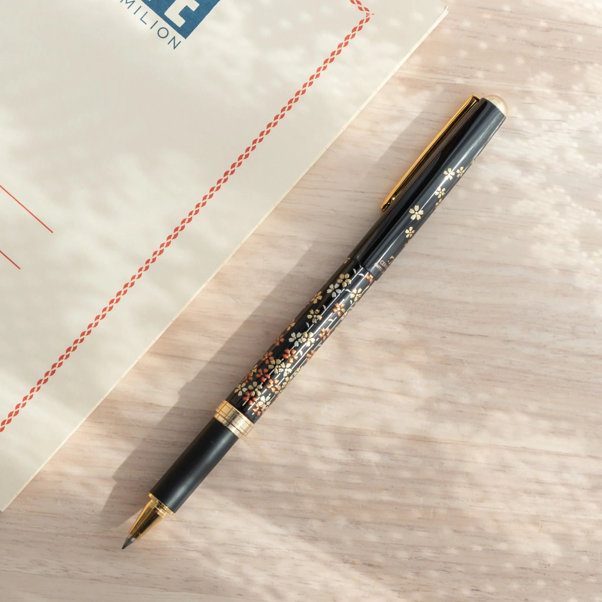 Hand-painted Yamanaka lacquer ballpoint pen depicts spring cherry blossoms in soft color palette for writing