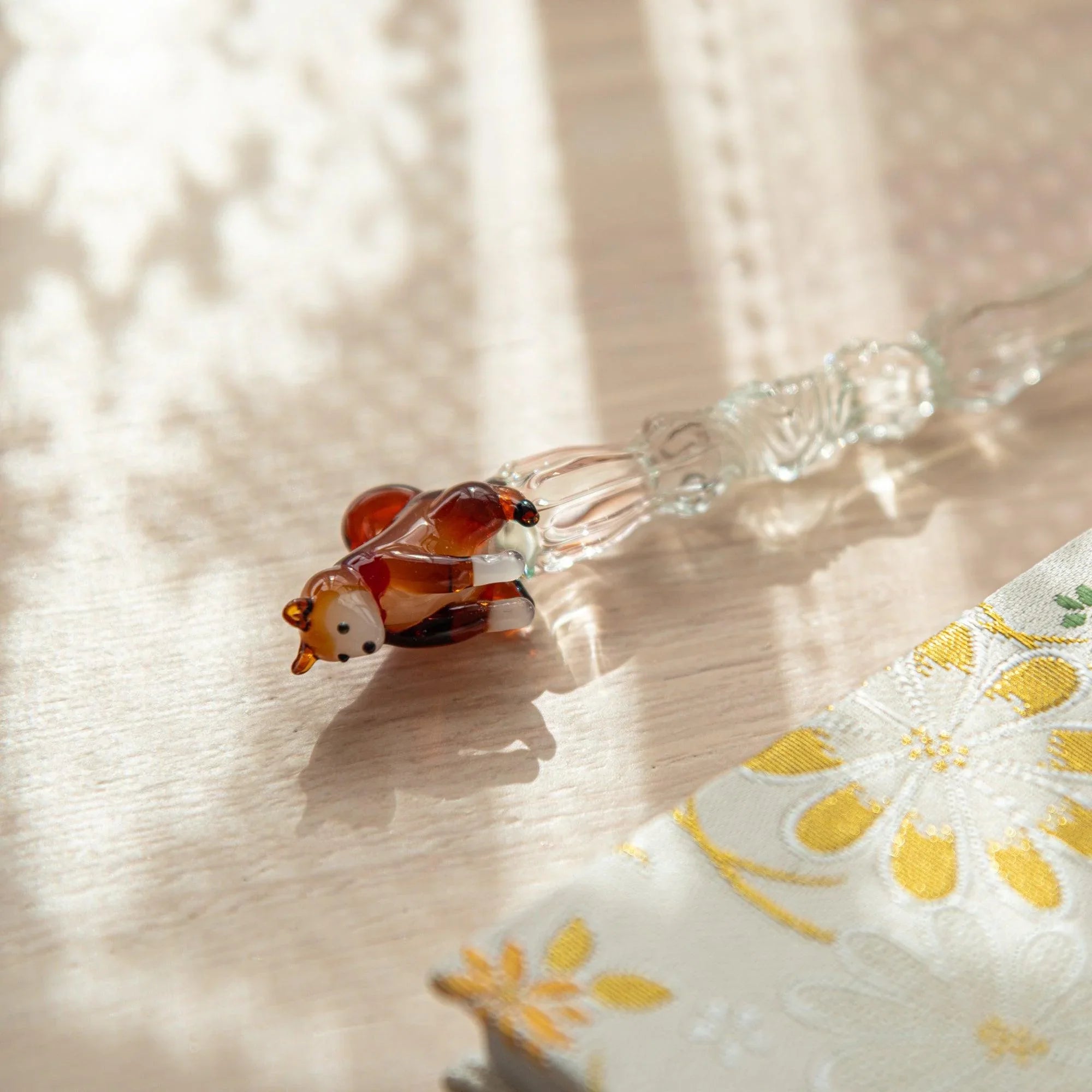 Japanese glass dip pen with reddish-brown ceramic Shiba Inu dog figure topper on clear glass barrel, close-up view