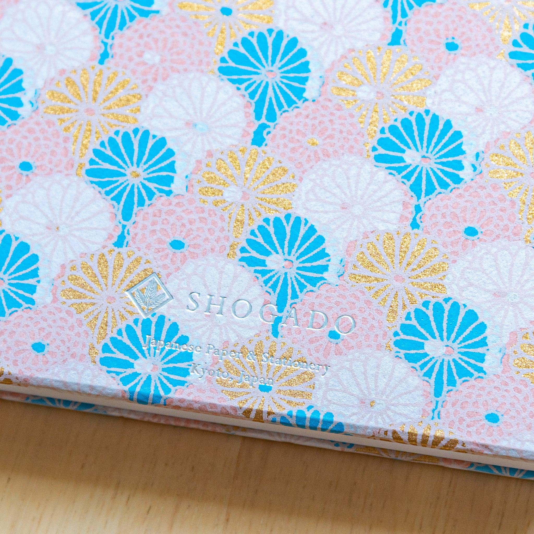 Sky Blossom Chrysanthemum Goshuincho detail showing pastel blue cover with flower design and traditional washi texture