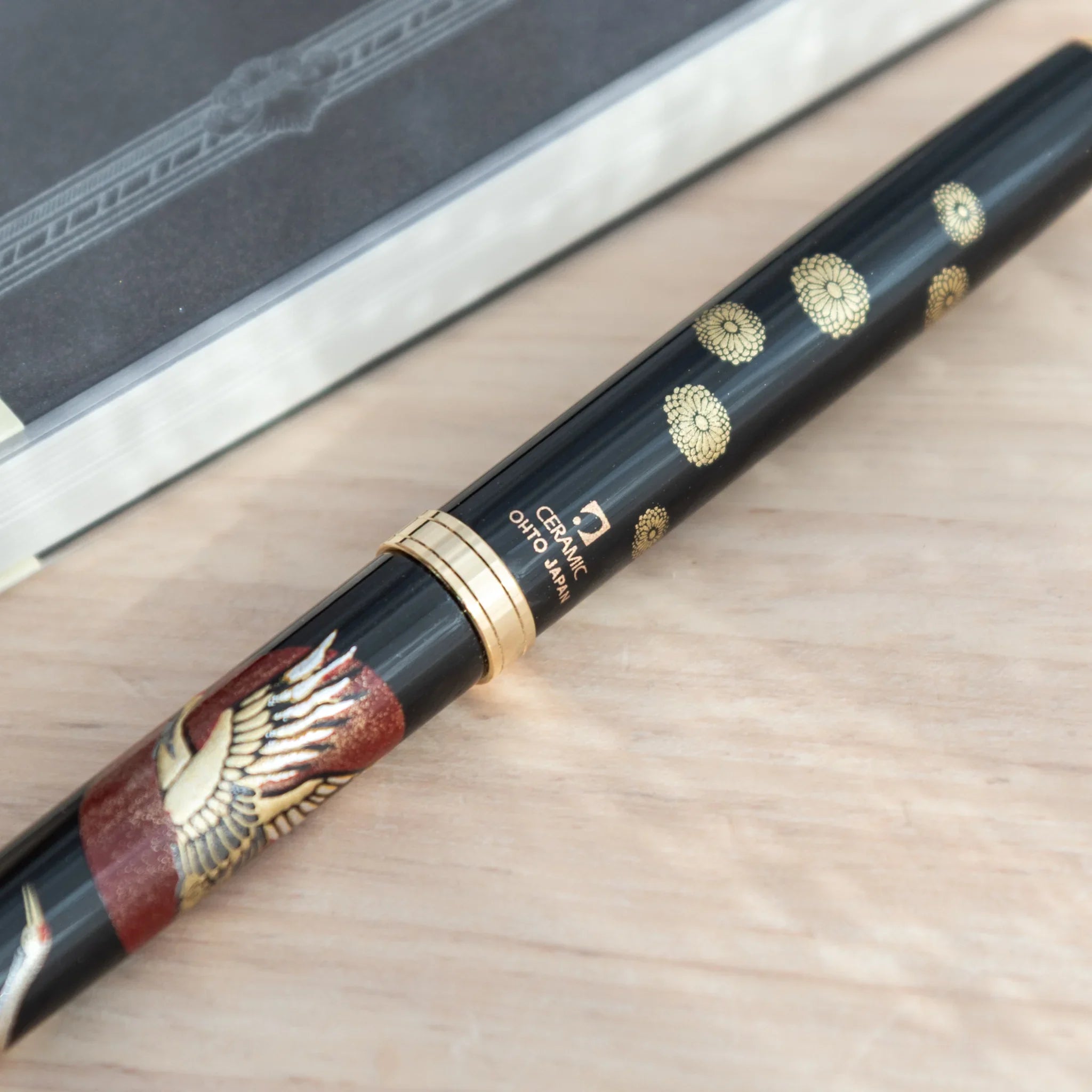 Close-up of Japanese ballpoint pen tip showing ceramic ballpoint, gold ring, and Ceramic Ohto Japan label on black barrel