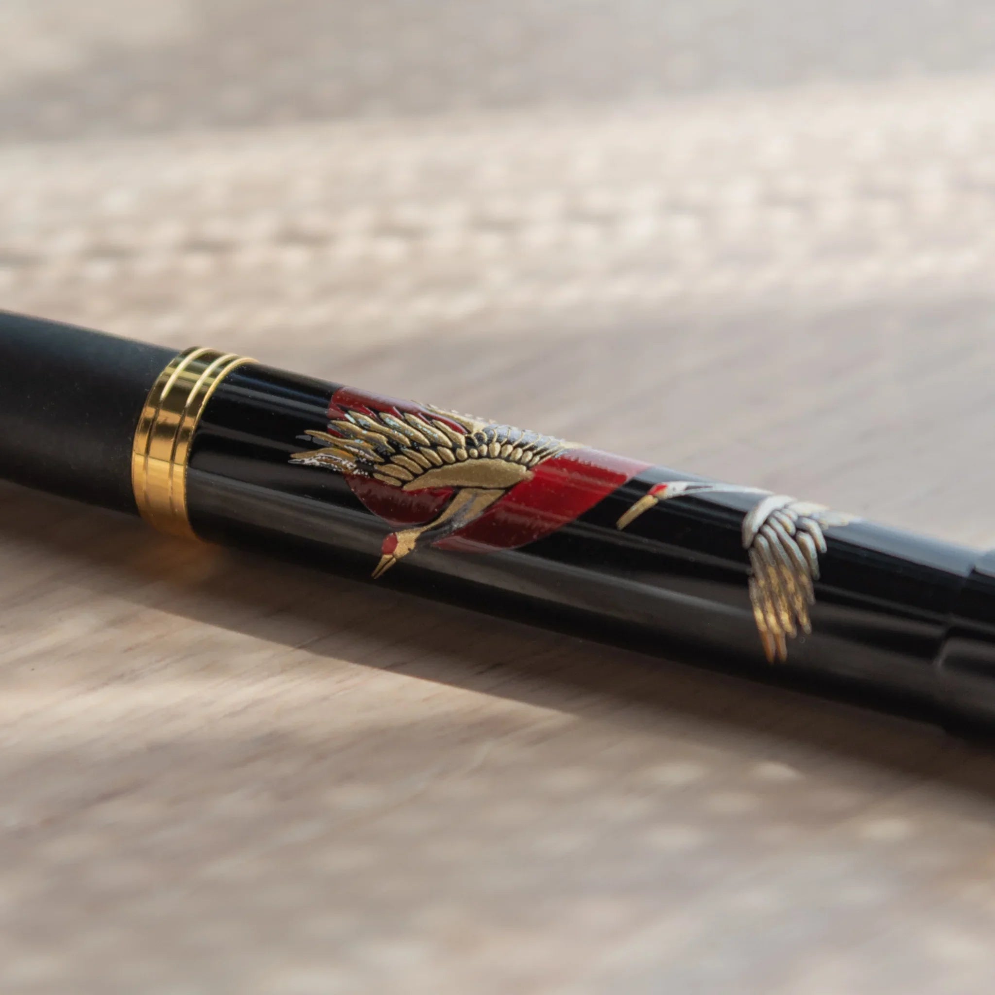 Hand-turned Yamanaka wooden fountain pen features crane birds and golden sunrise lacquer art for writing