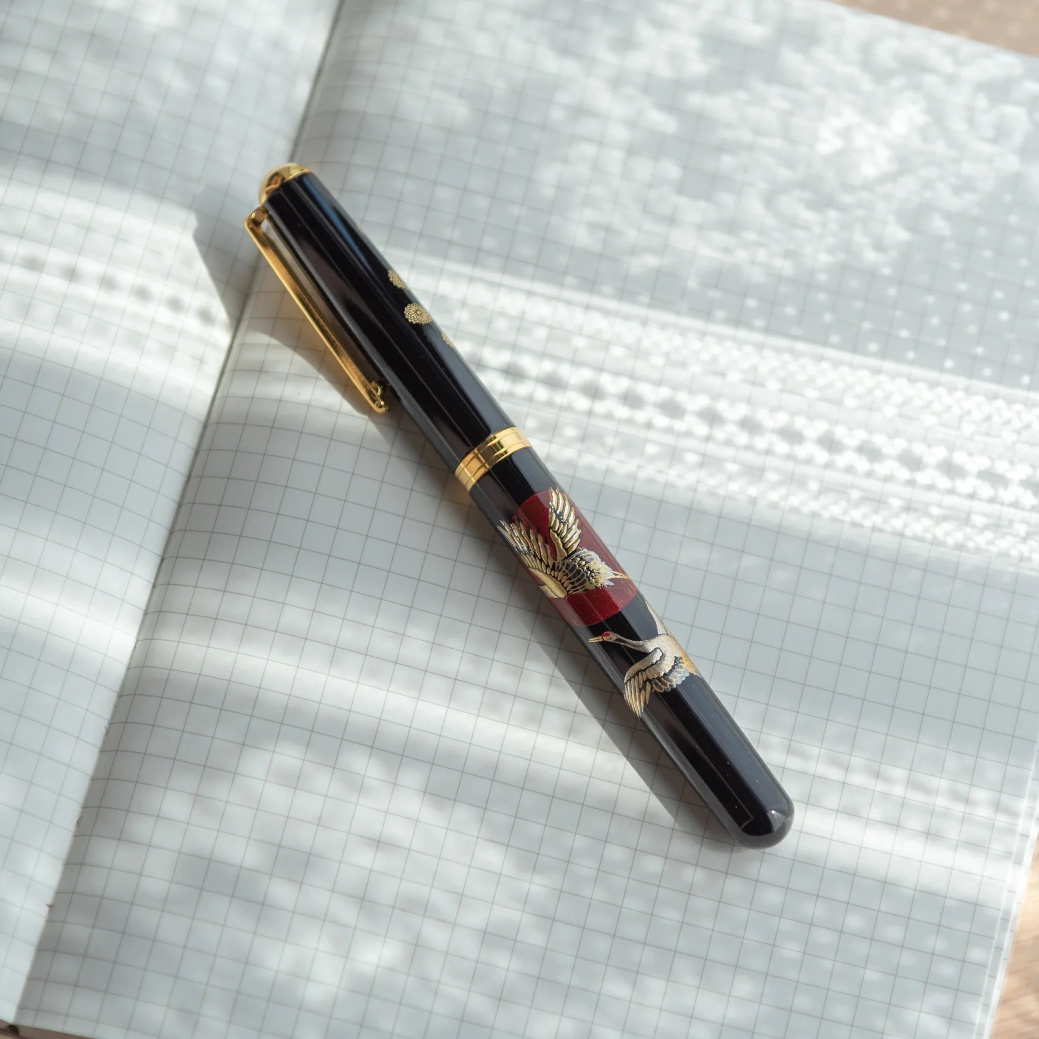 Golden Yamanaka fountain pen features detailed crane birds and sunrise landscape design artwork for writing
