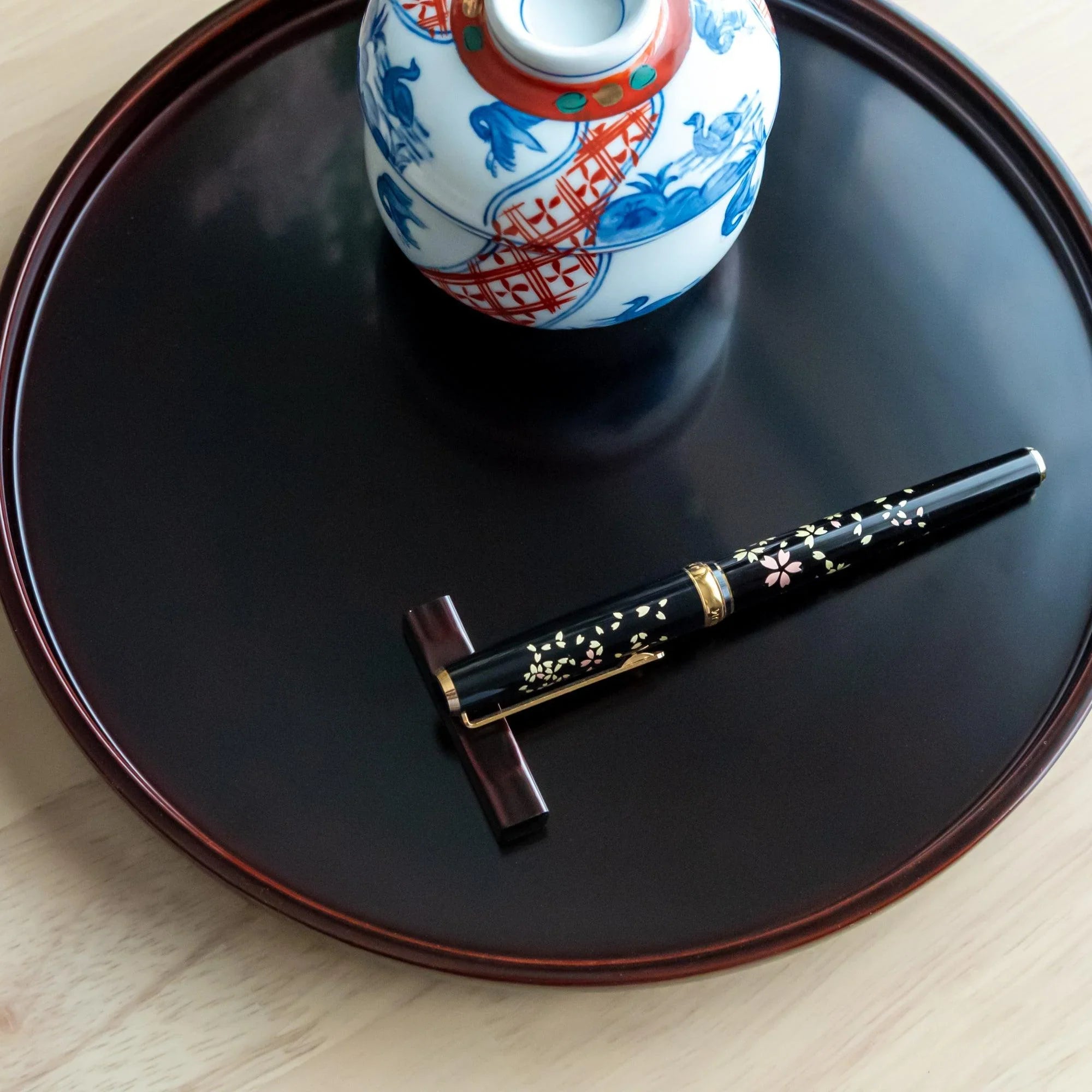 Japanese Echizen Tame-Nuri black lacquer pen rest on sakura wood with wabi-sabi aesthetic, keeping pens secure during work
