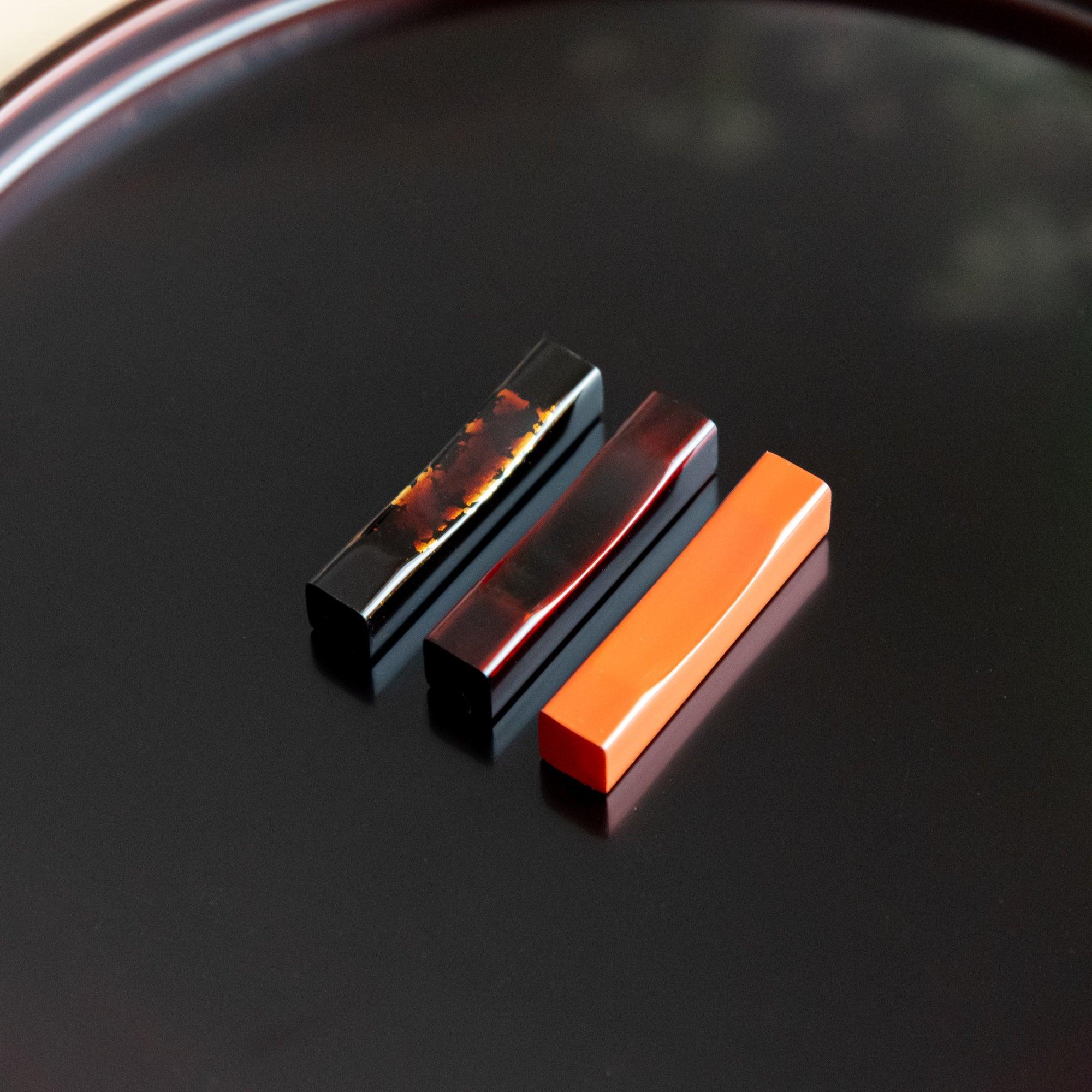 Traditional Echizen Tame-Nuri black lacquer pen rest features distinctive aged lacquer surface, keeping pens secure during