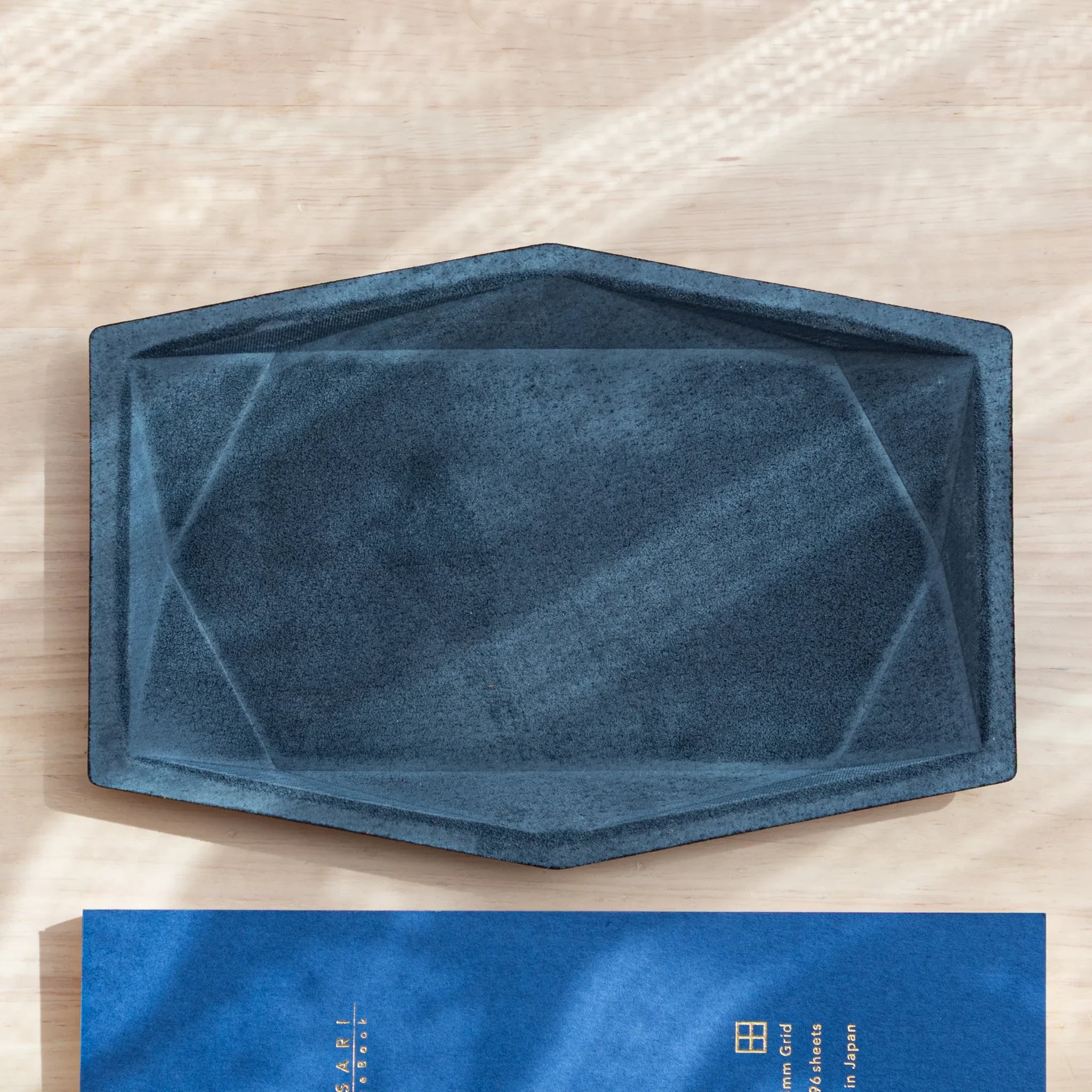 Blue-gray suede wide hexagonal pen tray overhead empty showing geometric hex shape and faceted interior walls