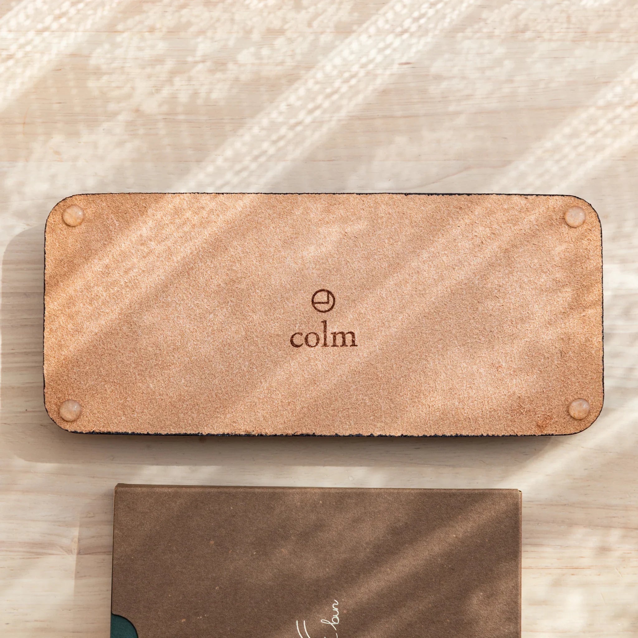 Olive green suede close-up with colm brand mark on underside material of the pen storage tray shown here