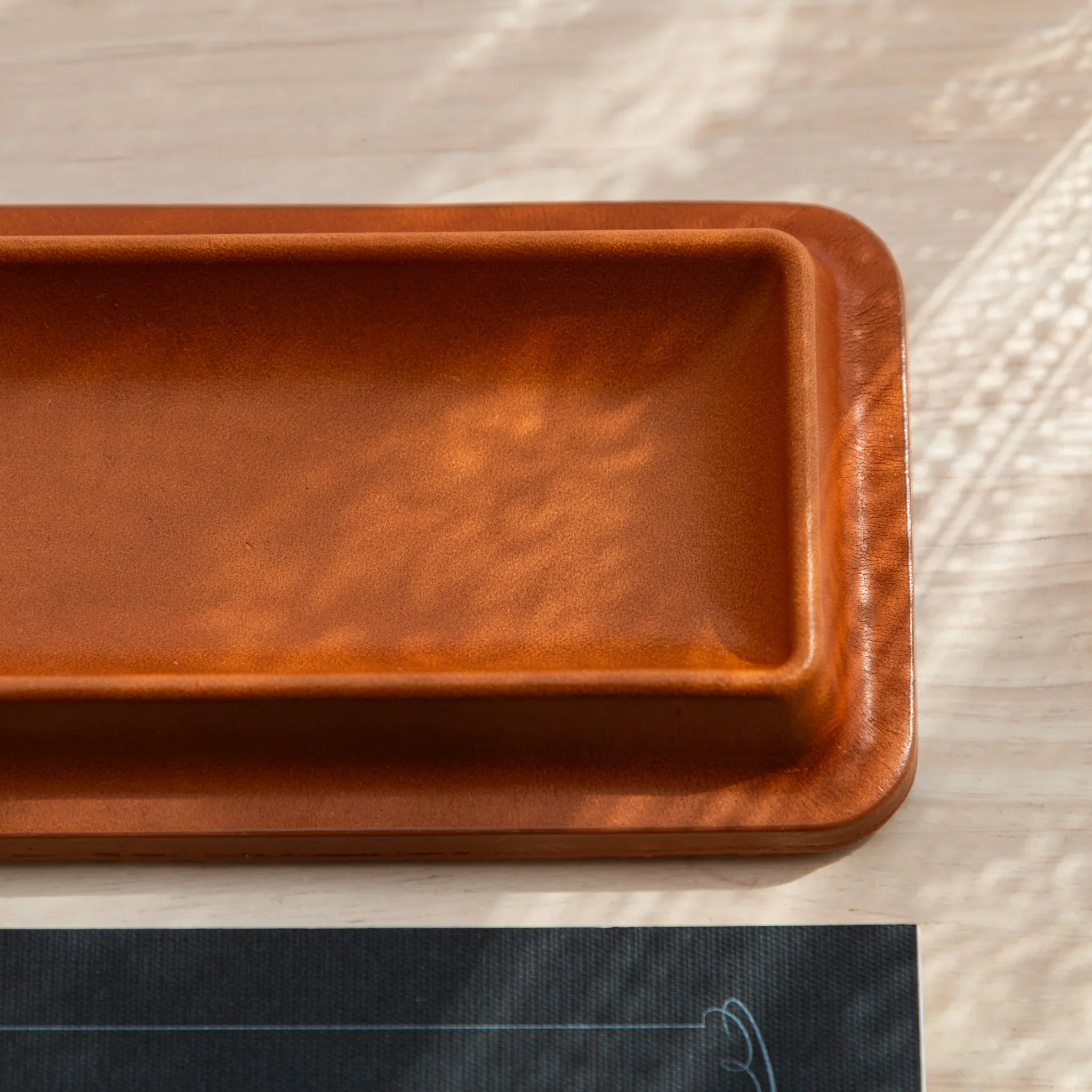 Cognac leather pen tray close-up showing smooth tan leather interior surface and fine leather grain texture