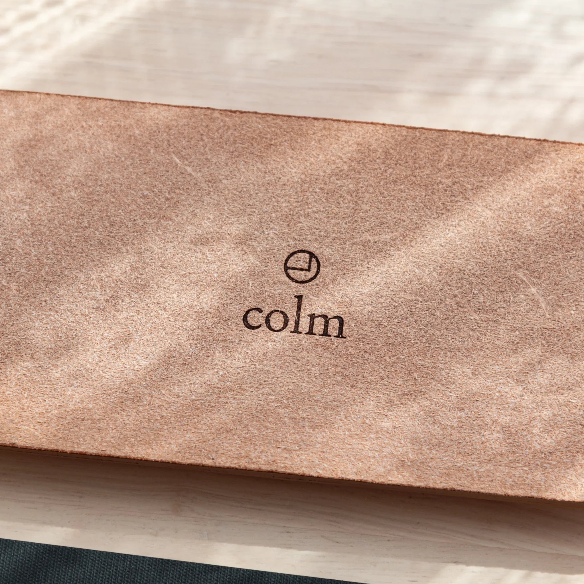 Tan suede pen tray interior close-up detail showing colm brand mark and material composition clearly