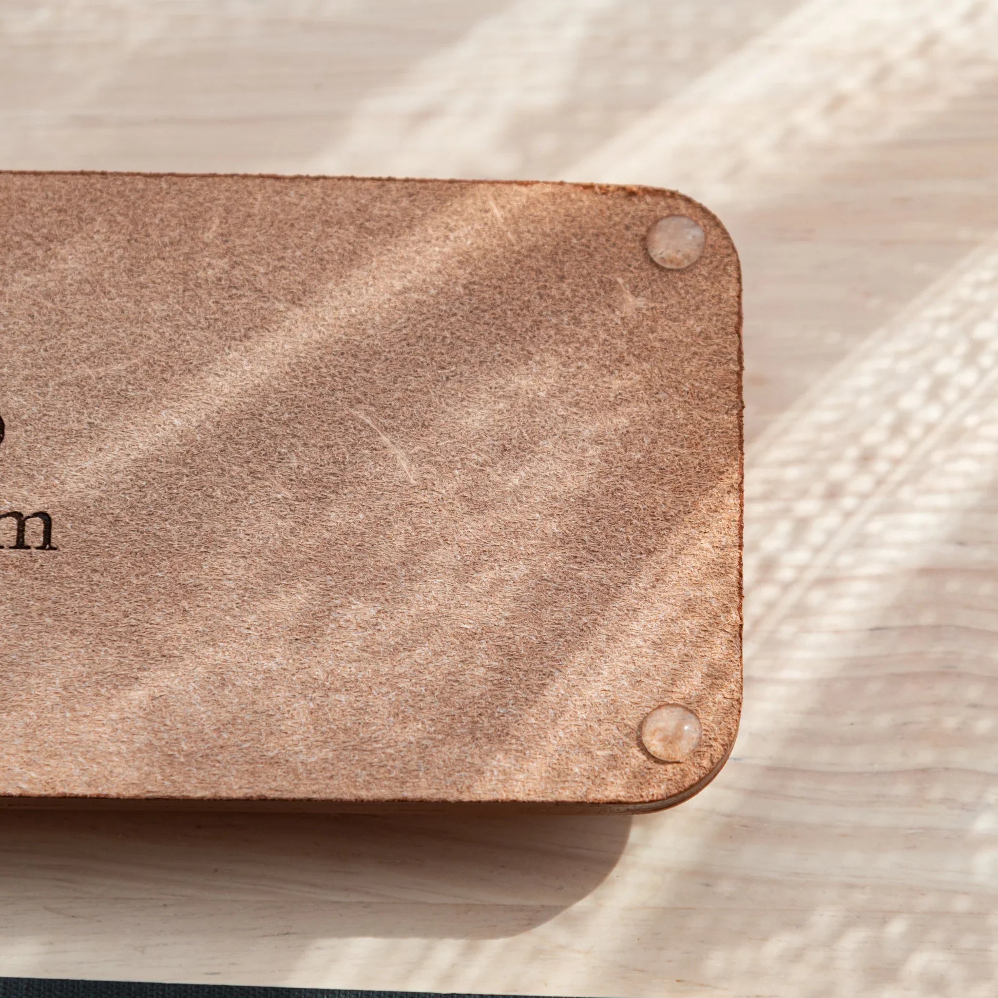 Tan suede corner detail of pen tray with exposed snap button closure hardware visible very clearly shown
