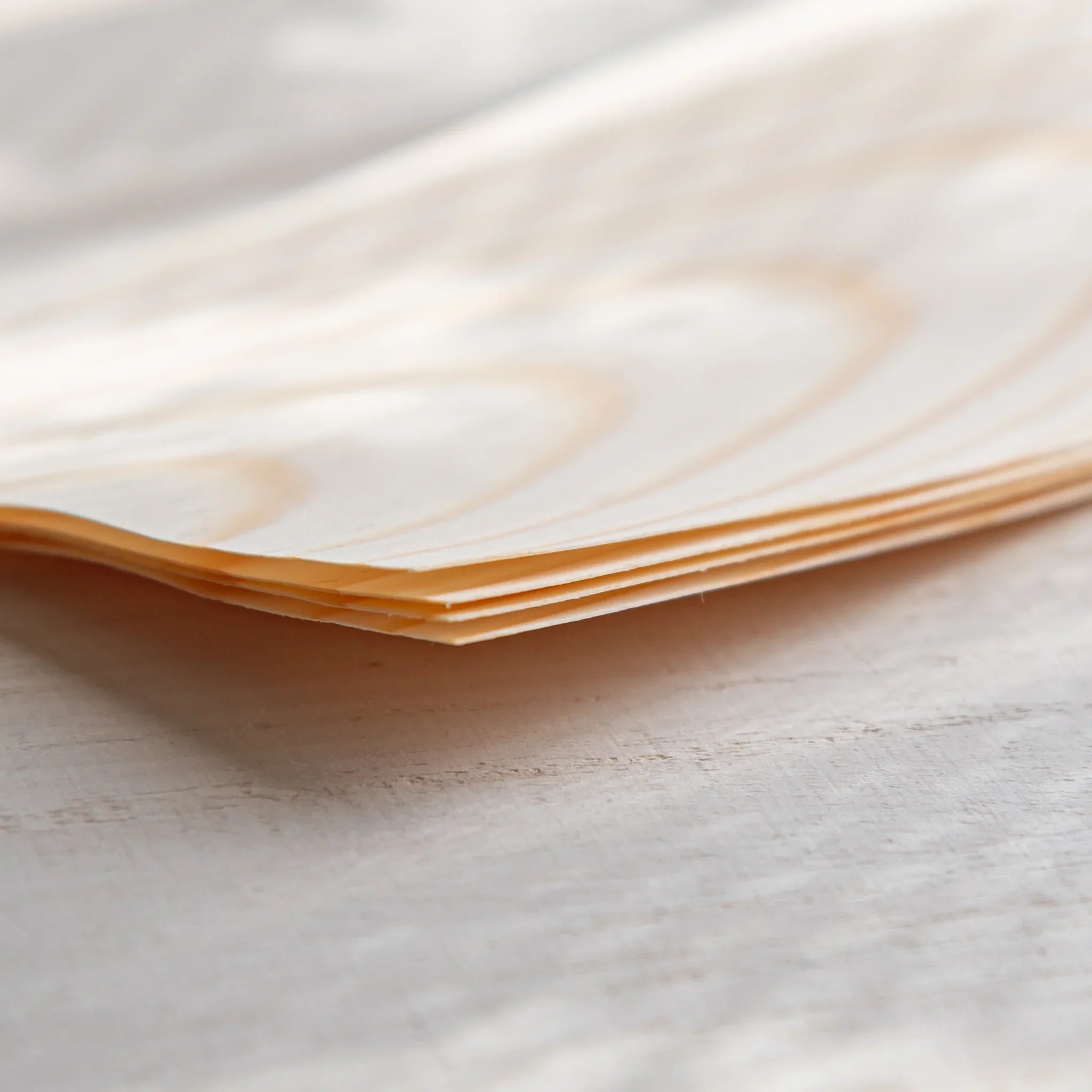 Japanese Stationery thin wood message cards stacked in a close-up view, showing their layered edges and natural pine grain