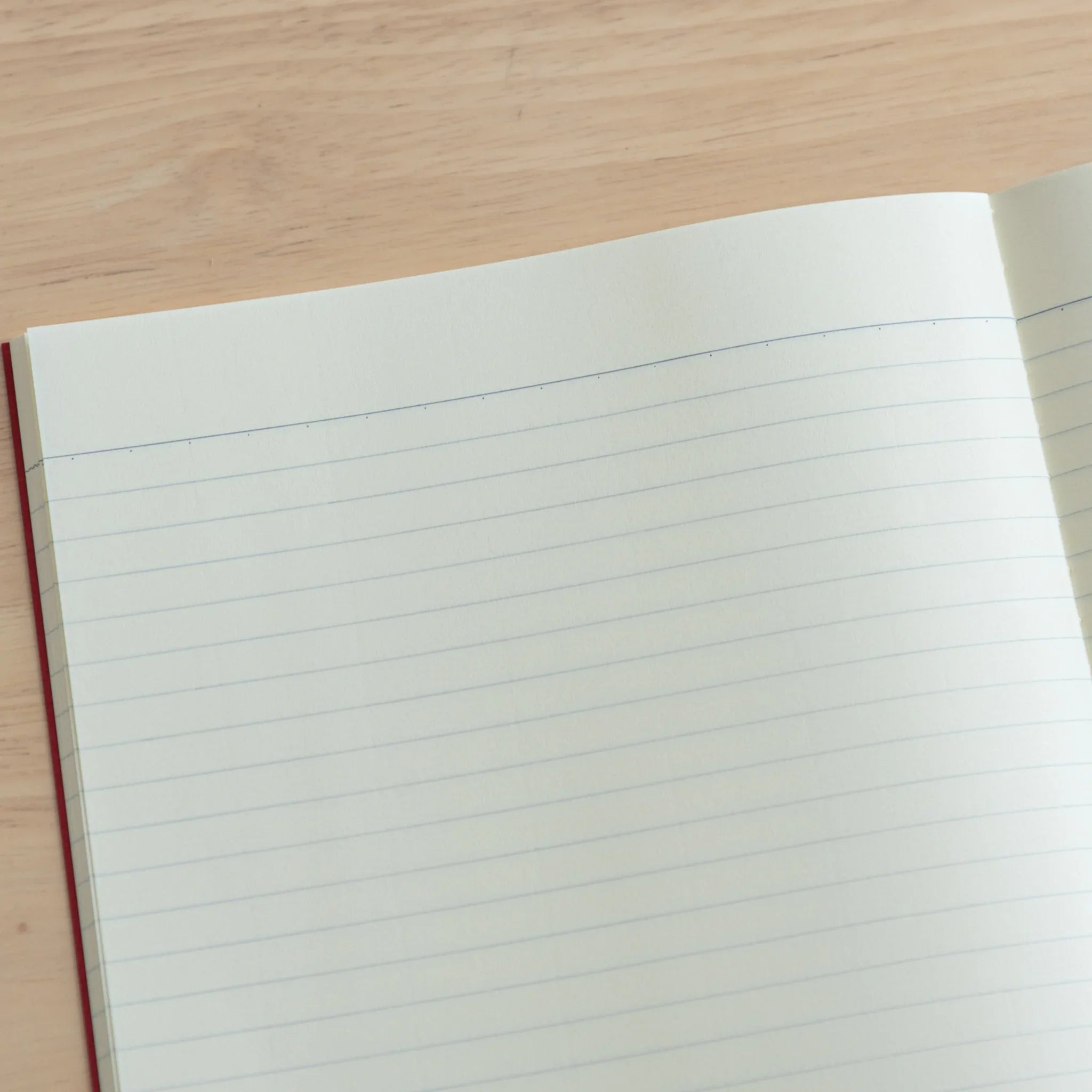Tsubame Fools Cream Notebook tilted angle showcasing thick cream paper with red fabric spine Japanese stationery